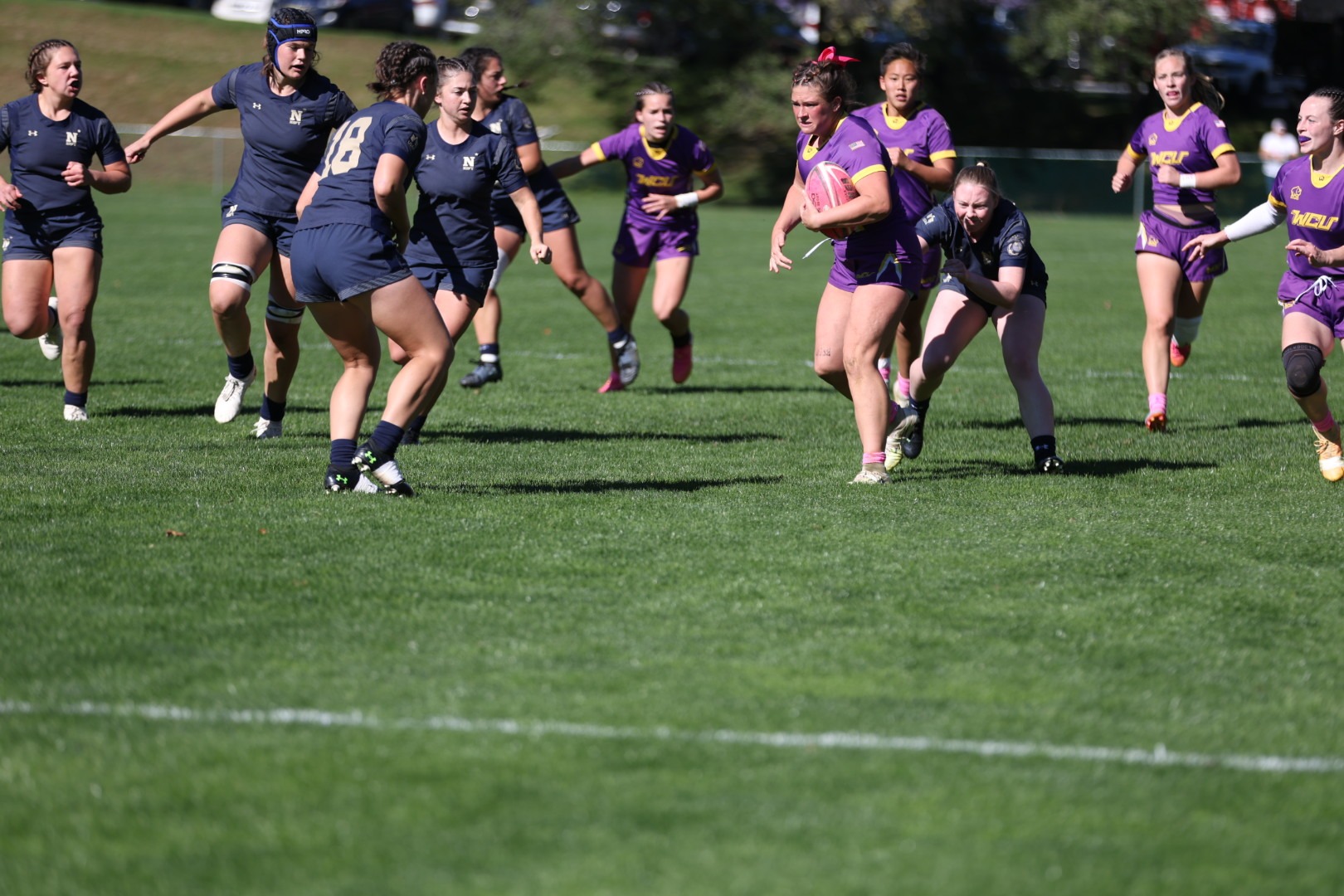 liv amann wearing purple top/purple short home uniforms with pink rugby ball fighting for meters against Navy on Sunday, October 18