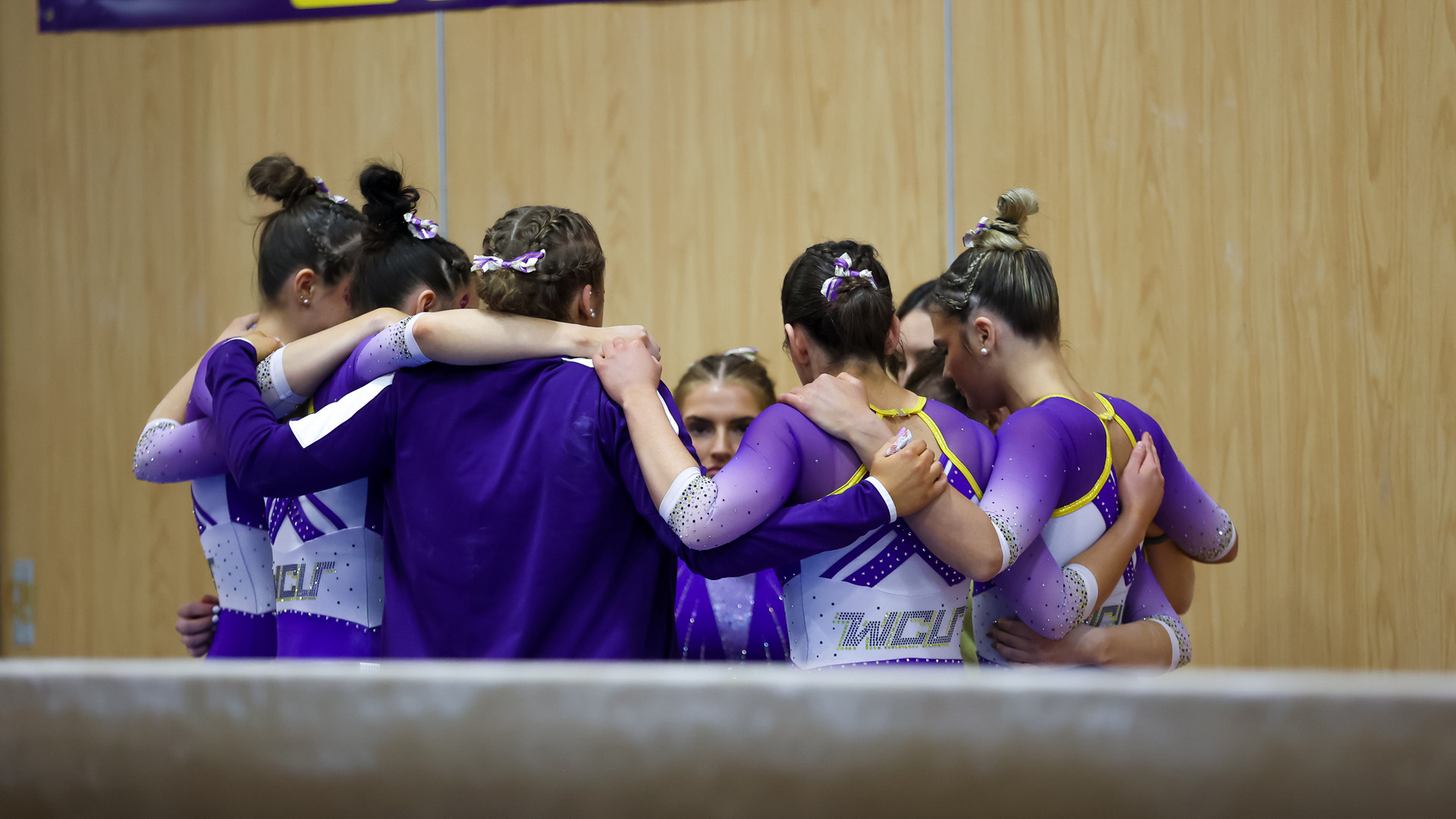 WGYM Teammates huddle at balance beam