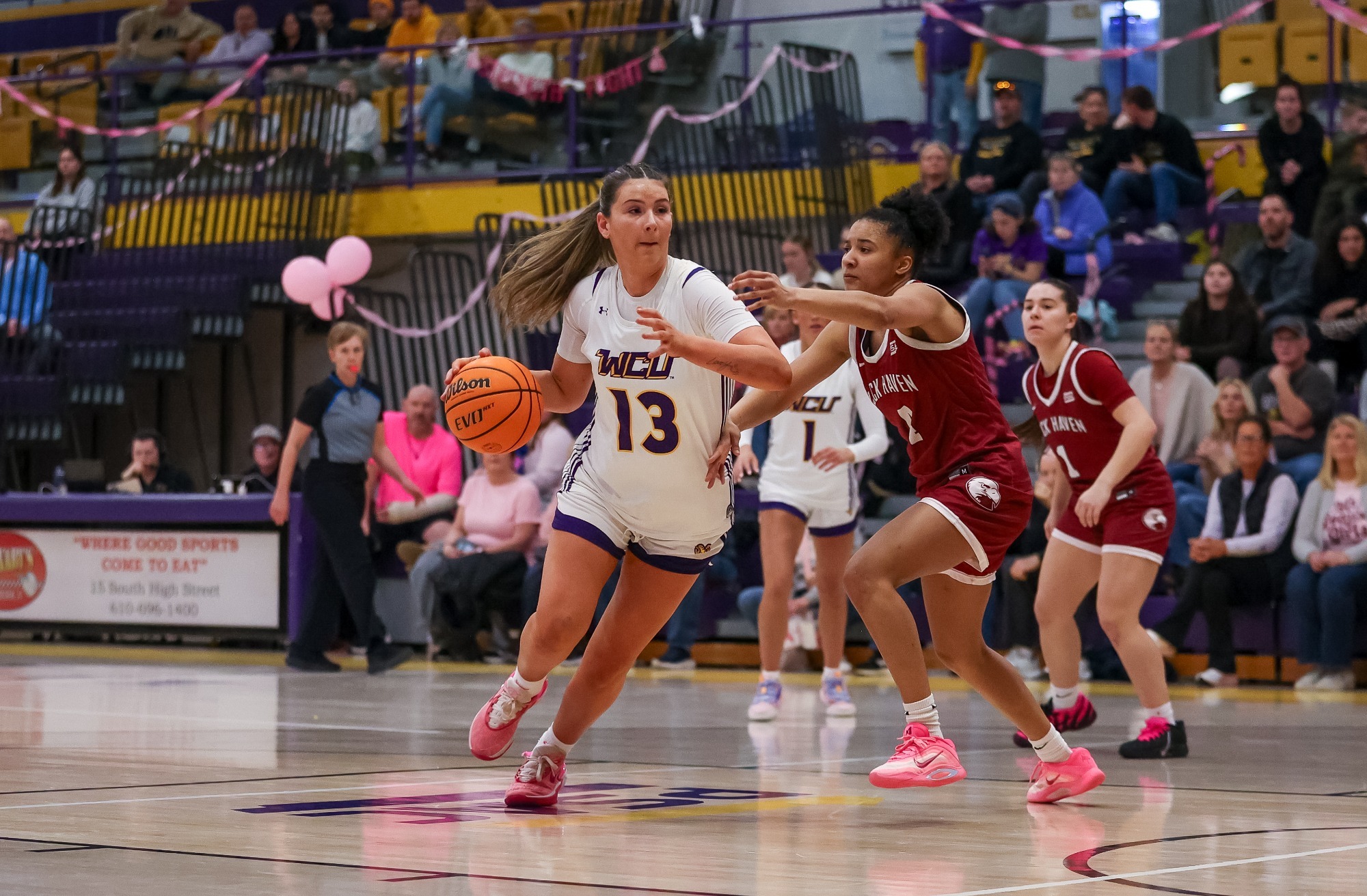 Marianna Papazoglou wearing team issued home white uniform drives the lane vs Lock Haven on 2-21-26