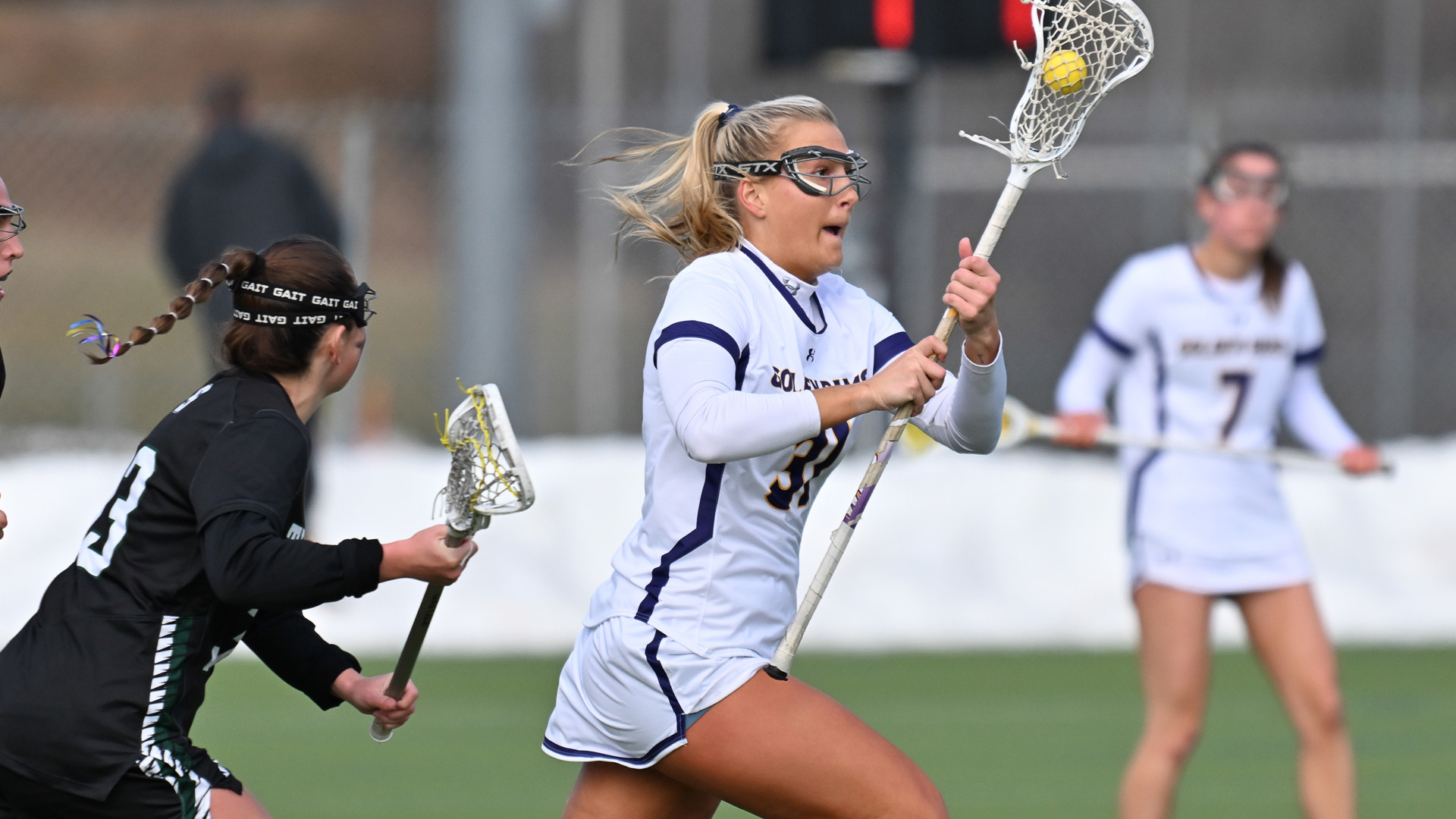Sydney Wasdick runs up field in West Chester's home white jersey with purple lettering and purple trim against Slippery Rock in the season opener.