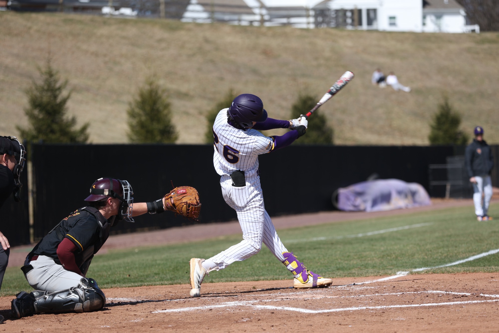 Landen Rozich swinging bat wearing white home pinstripe uniform vs Gannon on Saturday afternoon