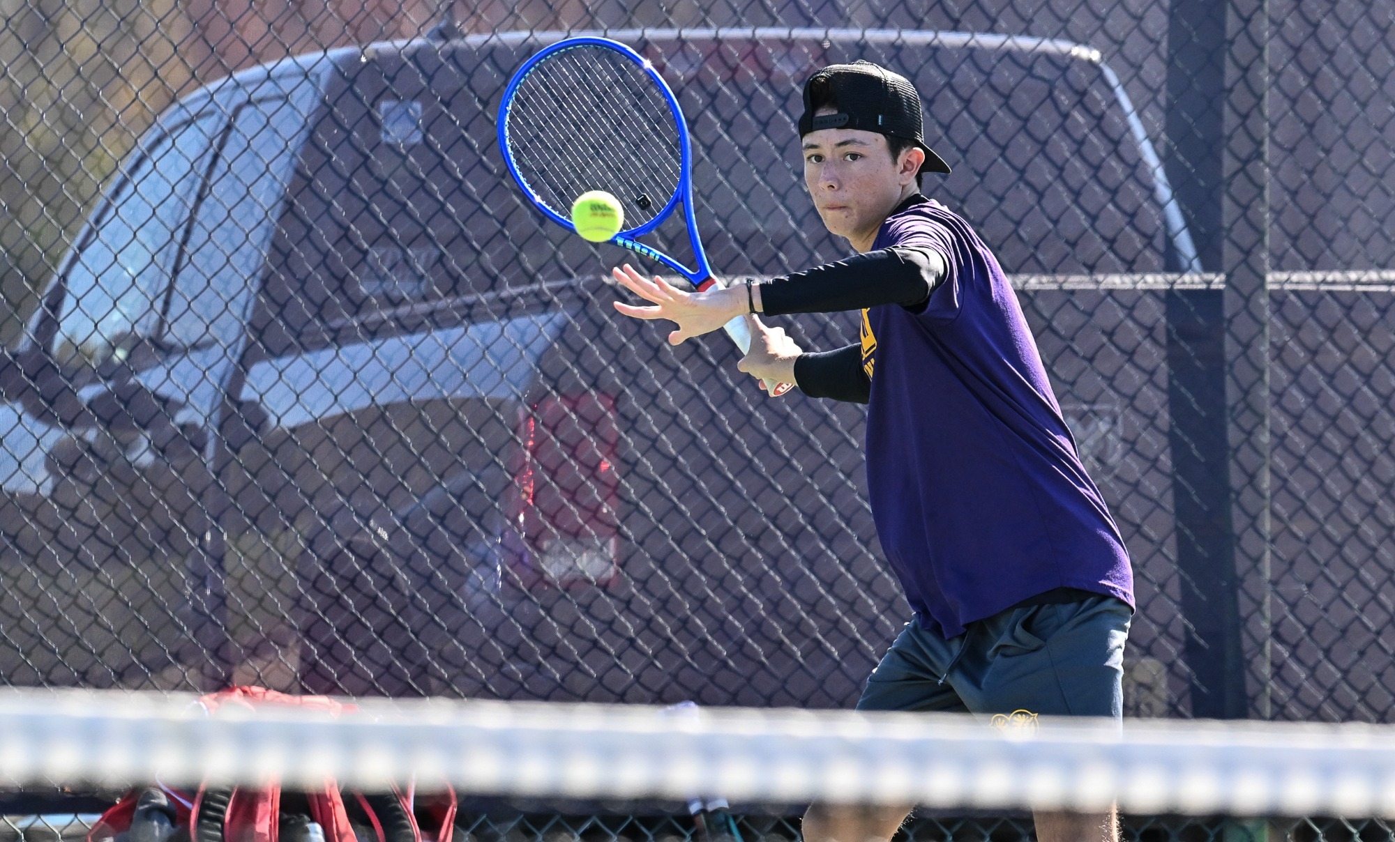 Men's Tennis player in purple shirt playing vs STAC