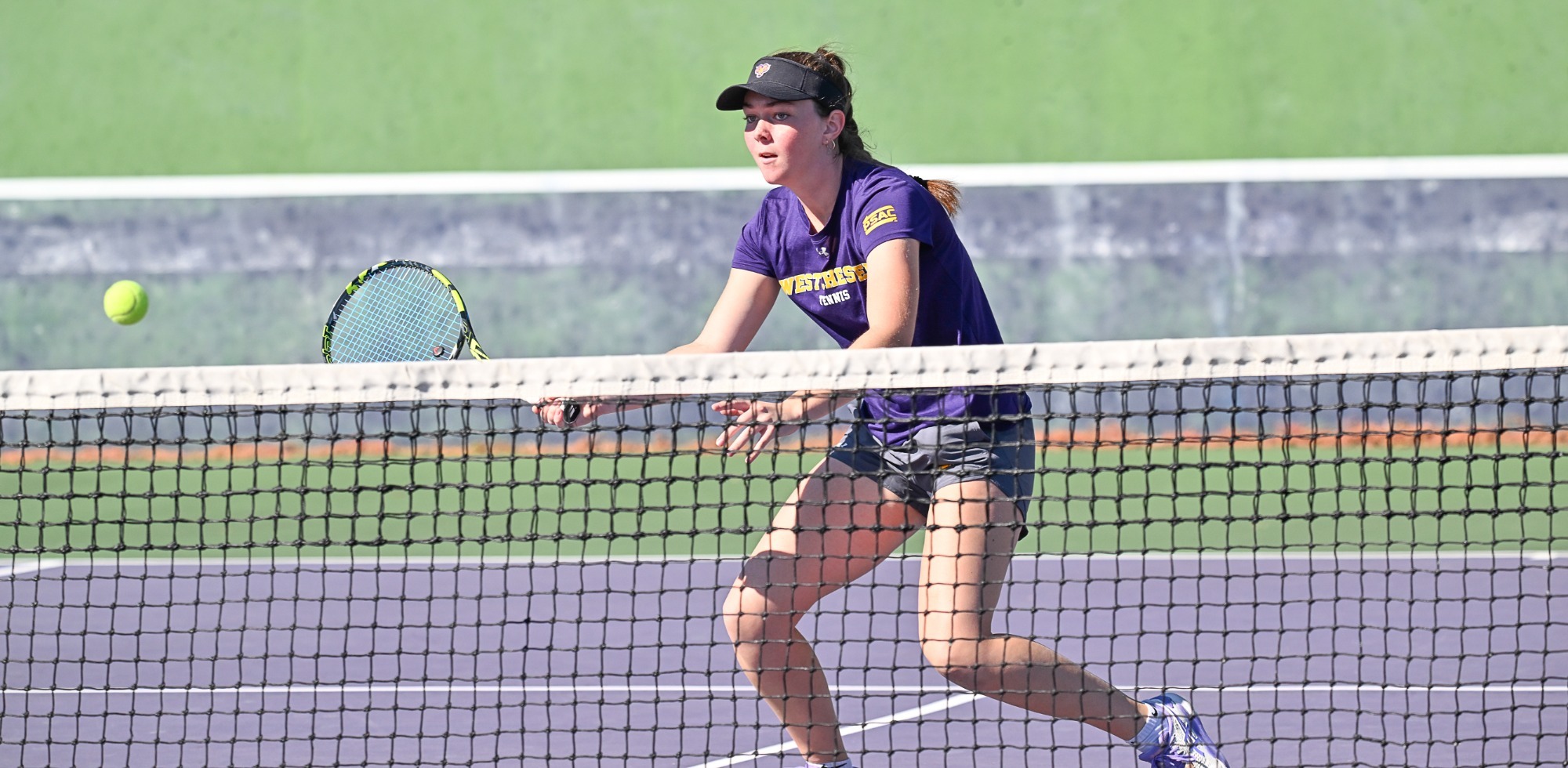 Brigitte Gravelle playing vs St. Thomas Aquinas wearing purple shirt and black hat during fall season