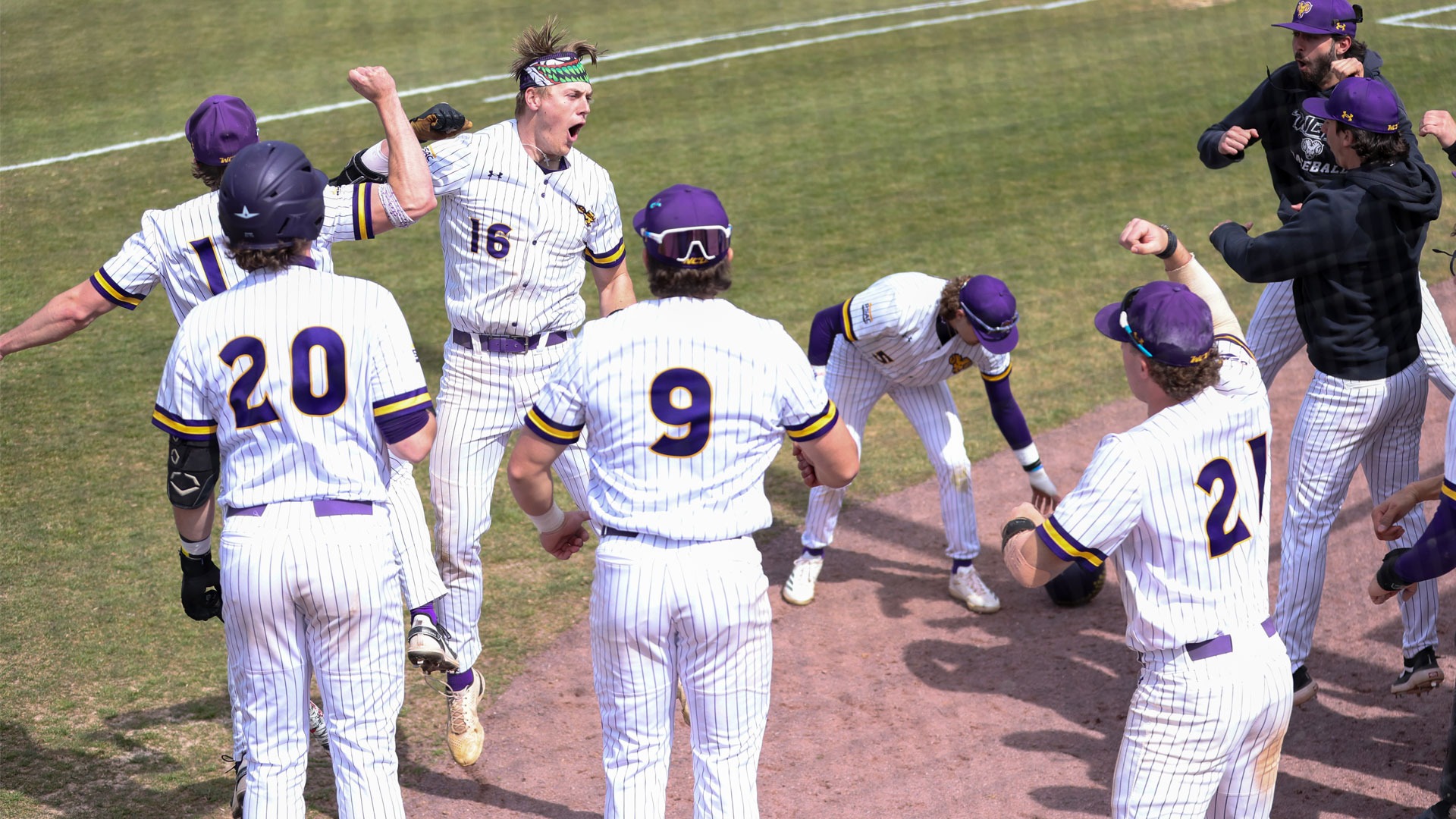 Austin Stalker wearing home white pinstripe uniform celebrates one of his three home runs vs Mansfield on Friday afternoon in the Golden Rams PSAC East Opener
