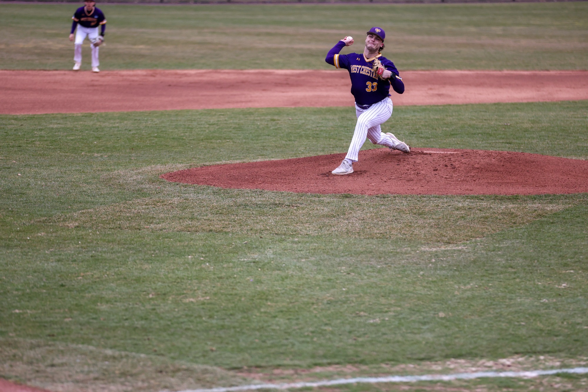 Kyle Lazer pitching vs Gannon wearing purple road top and white pinstripe pants on 3-15-26