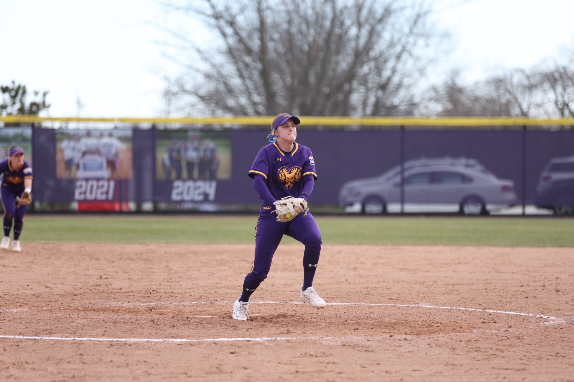 Maci Strechay pitching in new home purple uniforms vs Lock Haven on 3-21-26