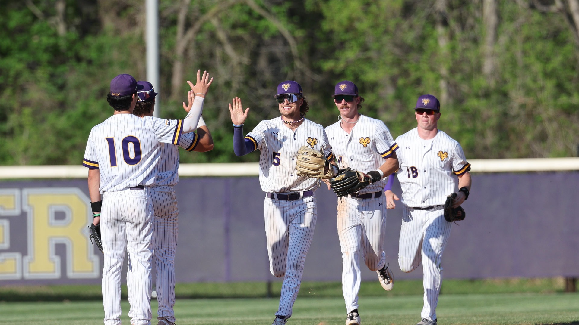 Golden Ram outfield (5, 11, and 18) running in with high fives following victory over Shepherd on Friday afternoon