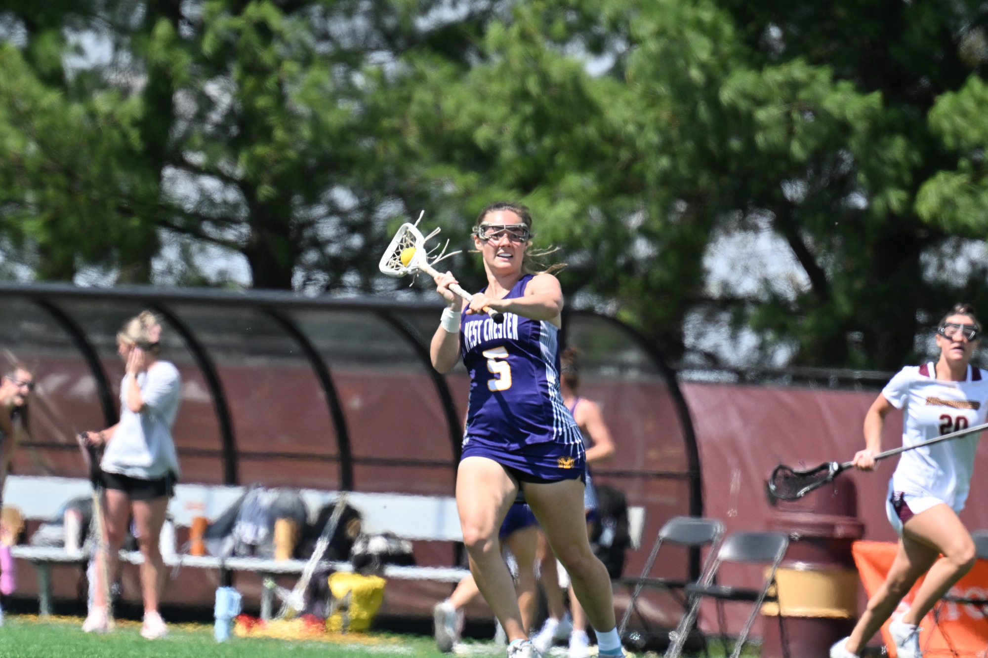 Kara Stewart looks to pace upfield on the clear at Bloomsburg in her road purple jersey with white numbers and yellow trim.