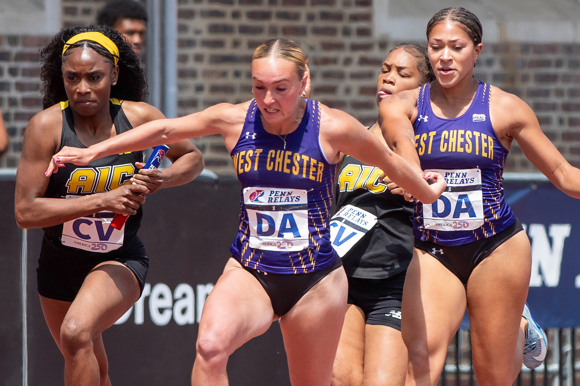 Katja Larsen reaches back to receive the baton from teammate Genevieve McDonald in the 4x100m at the Penn Relays 