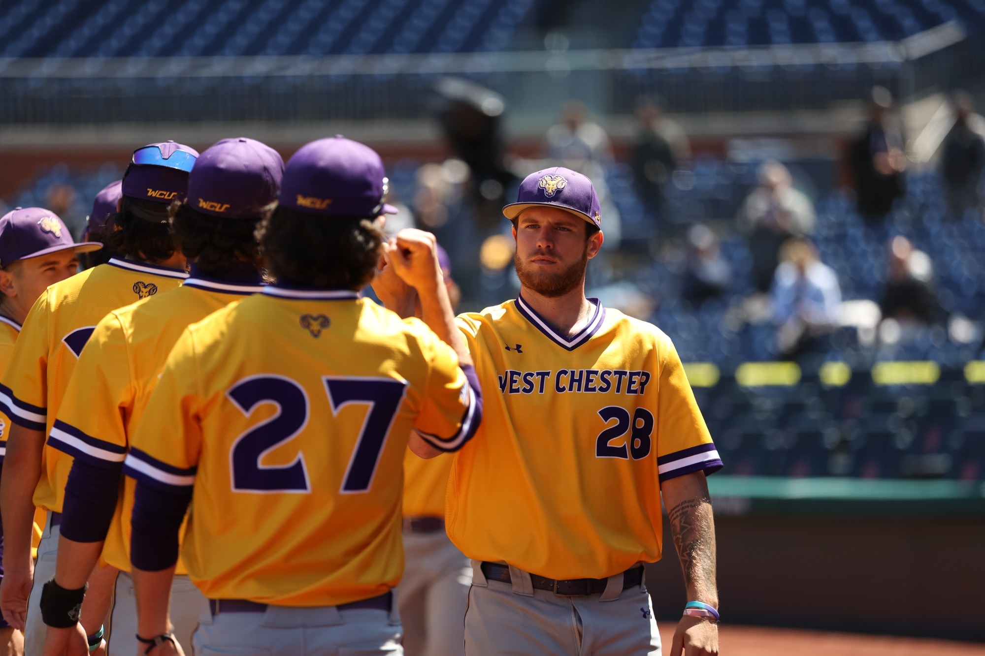 Julian Costa wearing gold top and gray pants going through handshake line during introductions at Citizens Bank Park for Bill GilesClassic