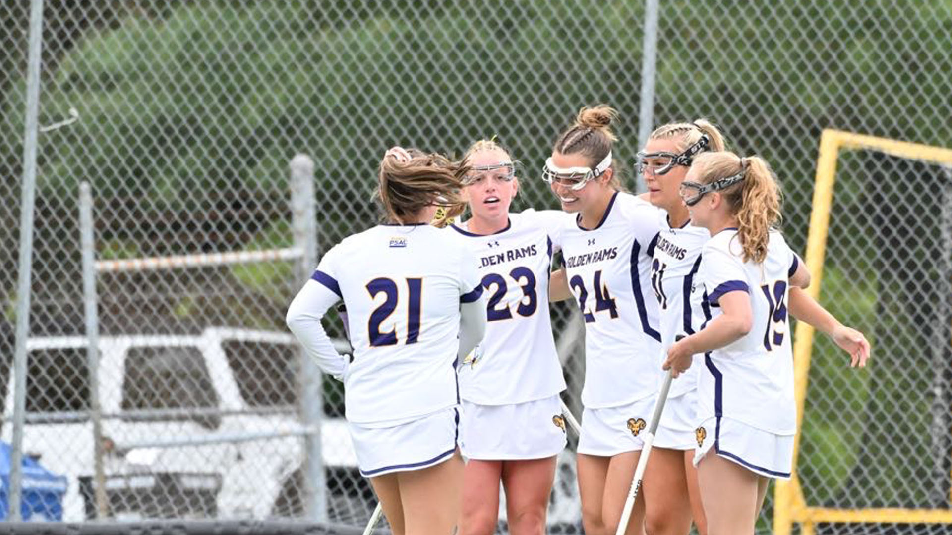 Five Golden Rams players huddle for a Goal Celebration vs Shippensburg at Vonnie Gros Field in their home white jerseys