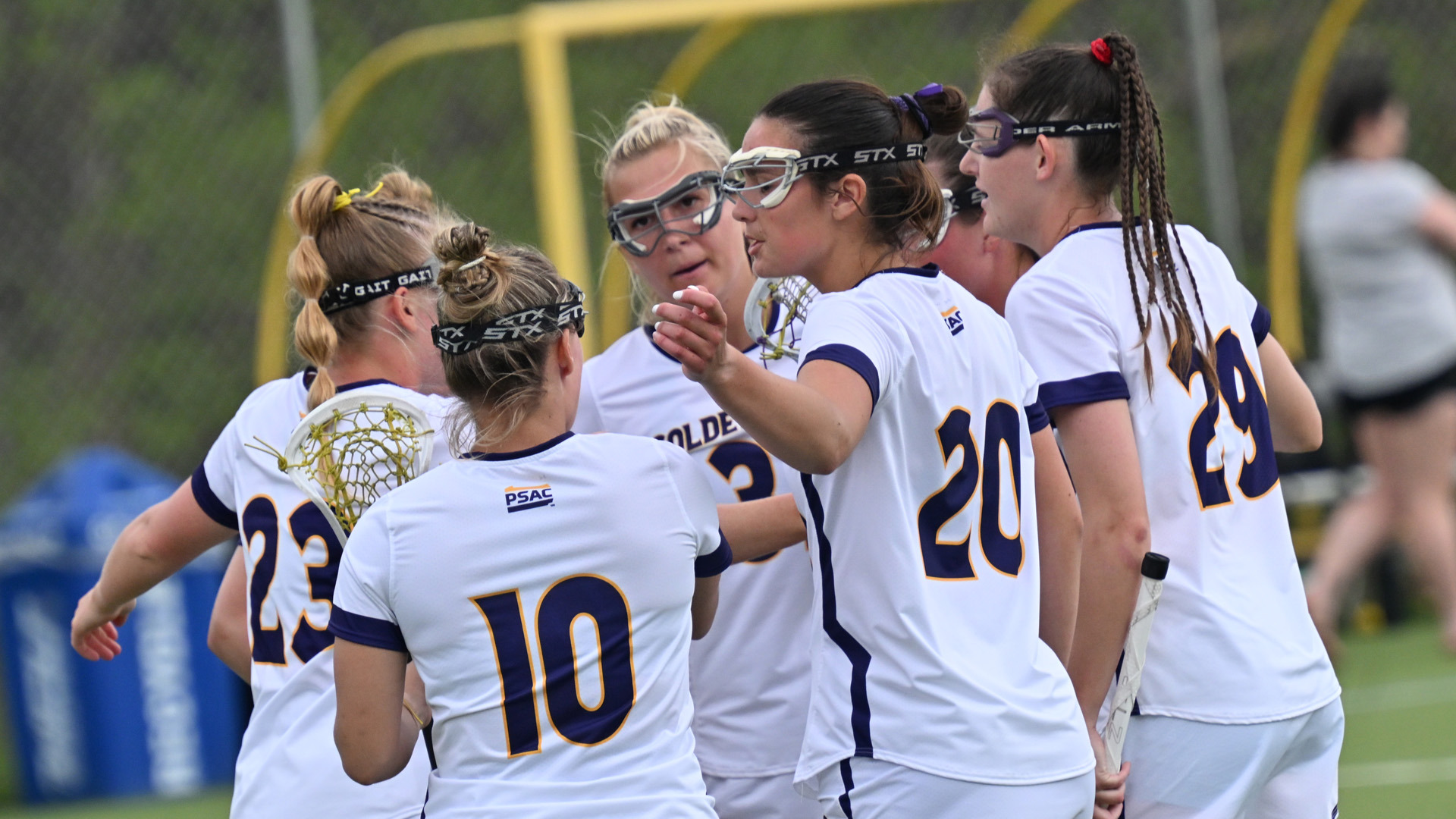 Five players celebrate a goal in a huddle. 