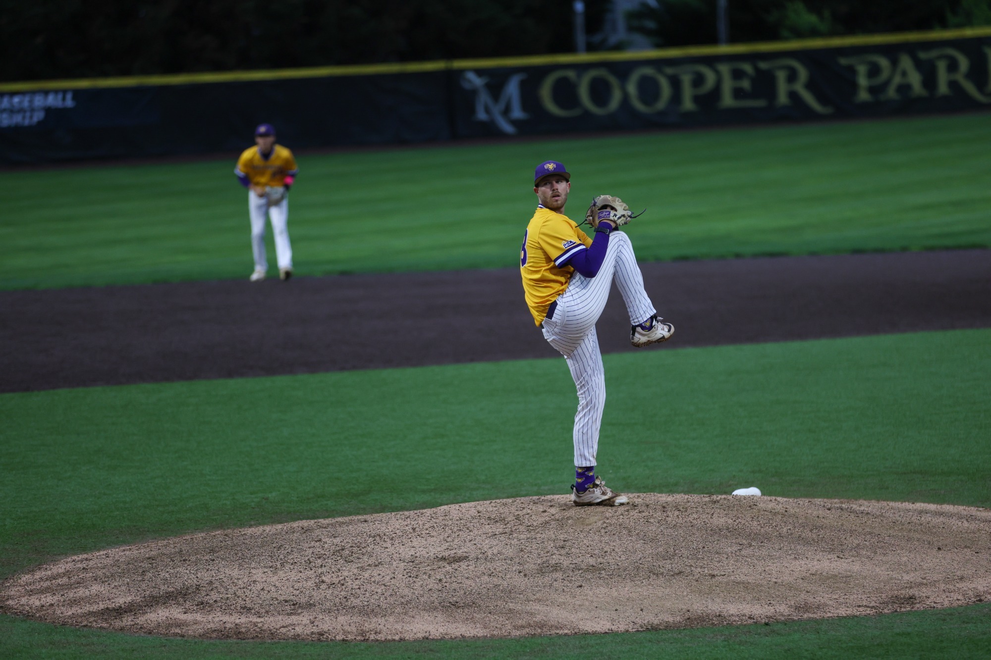 Julian Costa wearing gold top and white pinstripe pants pitching vs Ville in Super Regional Action on 5-21-26