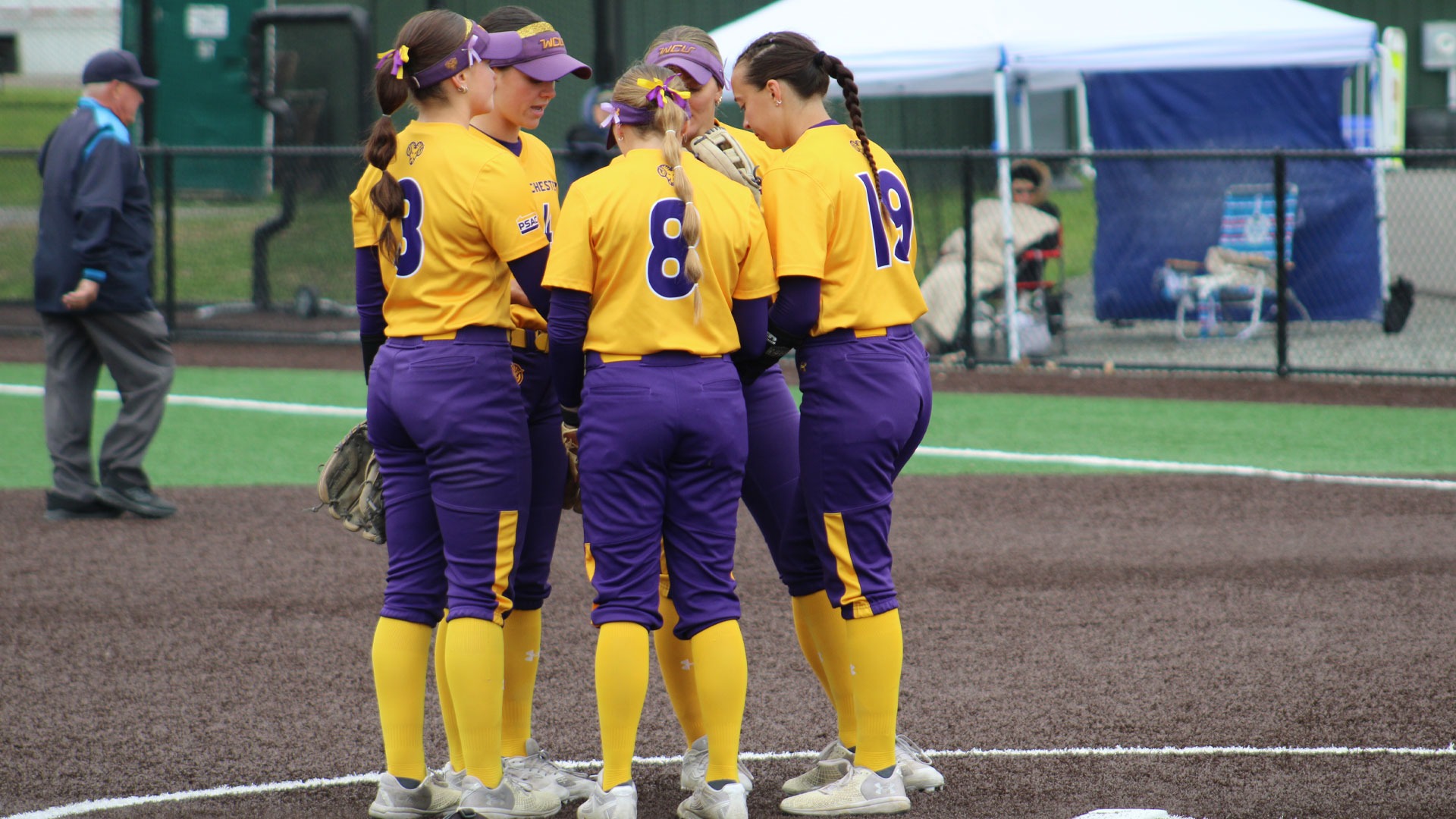 SB TEAM HUDDLE IN CIRLCE ON 5-8-26 vs IUP Golden Rams wearing Gold Tops and Purple Pants