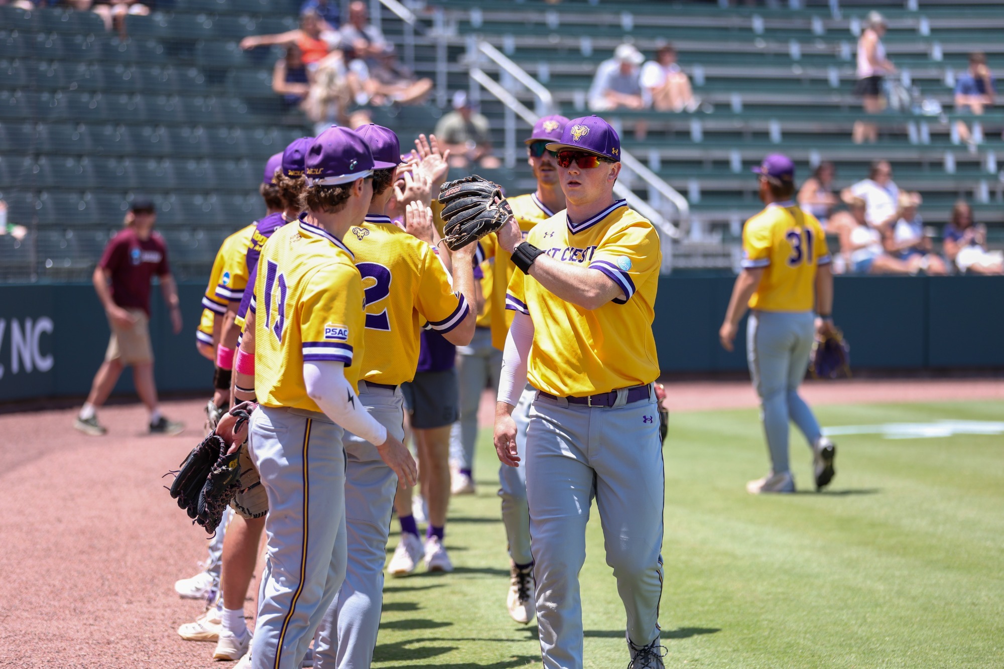WCU BASEBALL GOING THROUGH POST I/O HANDSHAKE LINE-HUNTER SMITH SMACKING GLOVES WITH A TEAMMATE