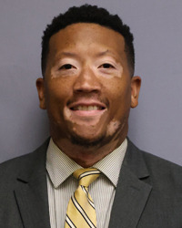 Glenn Hutton head shot in a jacket and tie