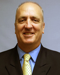 Tom Pajic head shot in a jacket and tie