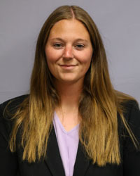 Hayley Tamaro head shot black blazer and purple blouse