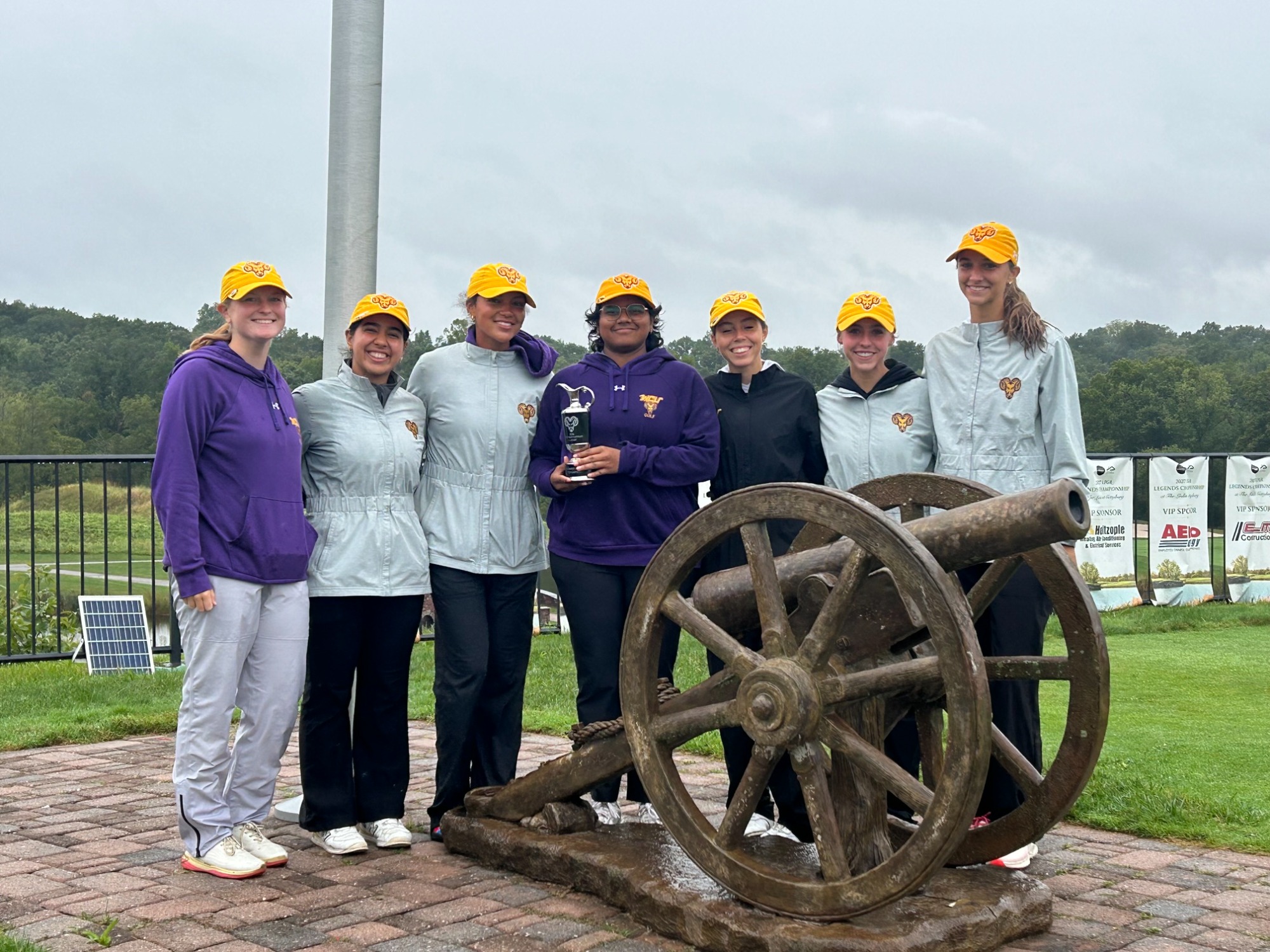 Women's Golf posing by cannon at the Links at Gettysburg with WCU Battlefield Classic team trophy