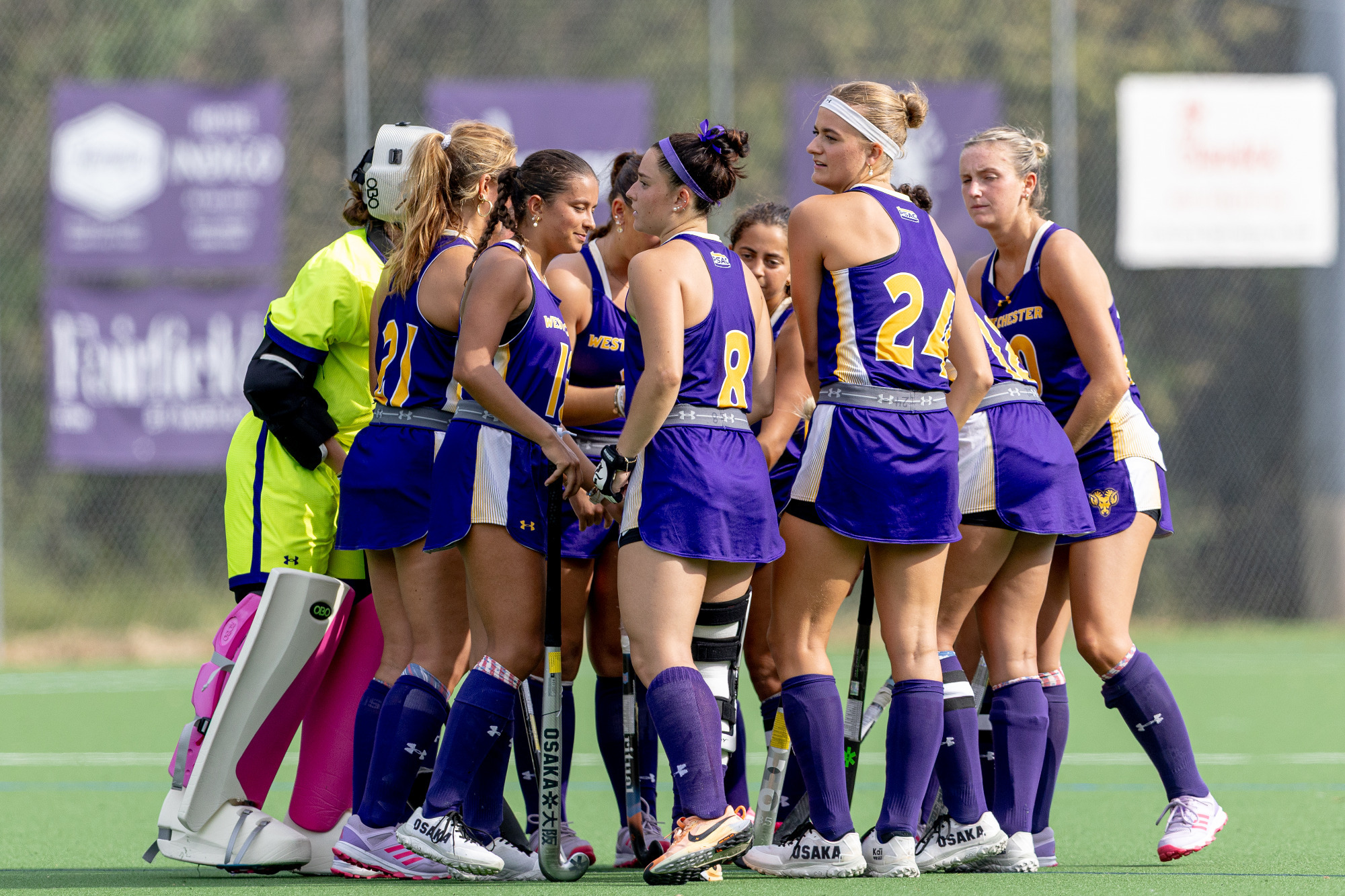 West Chester starters huddle on the field in their home purple jerseys