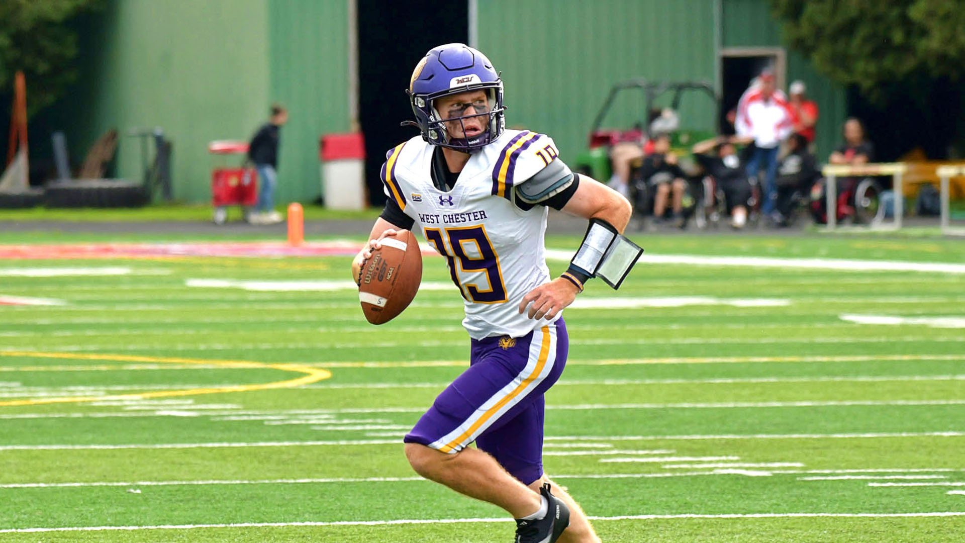 Colin O'Sullivan rolls out against Edinboro in his road white uniform with purple pants and purple helmet.