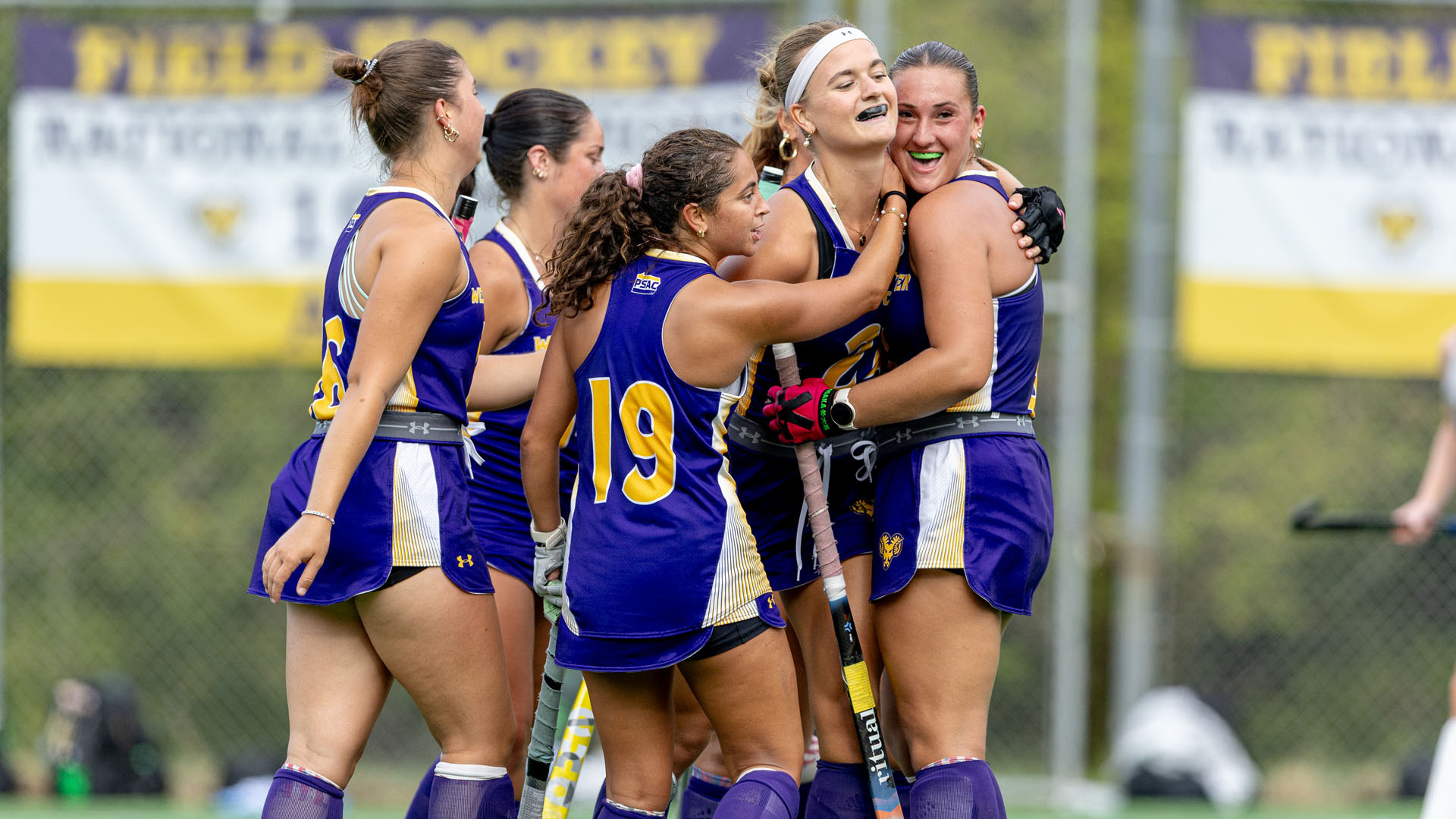 West Chester teammates hug Veerle Hersman after a goal at home in their purple uniforms against Millersville