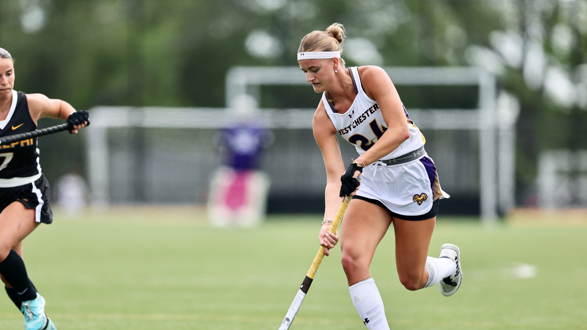 Veerle Hersman dribbles toward the goal against Adelphi in her road white jersey
