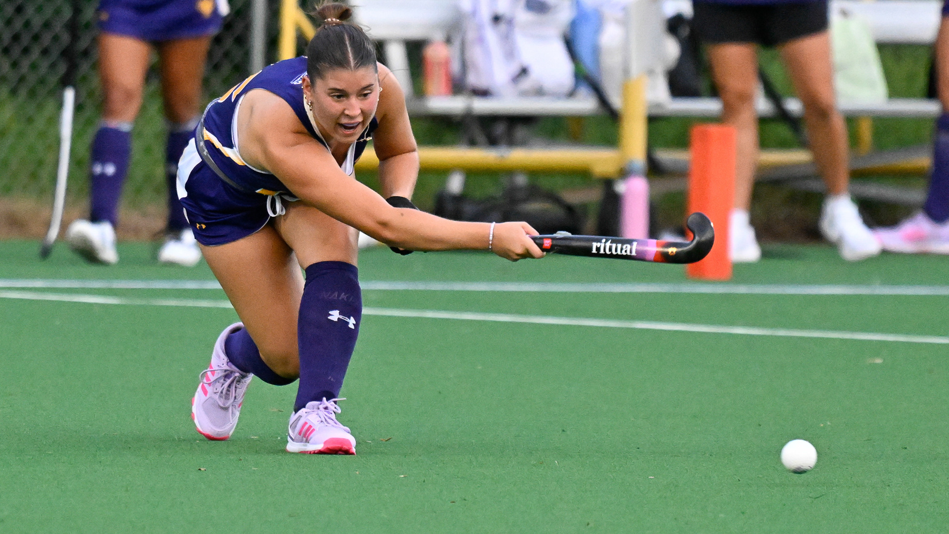 Nora Evans passes the ball against Assumption in her home purple uniform at Vonnie Gros Field