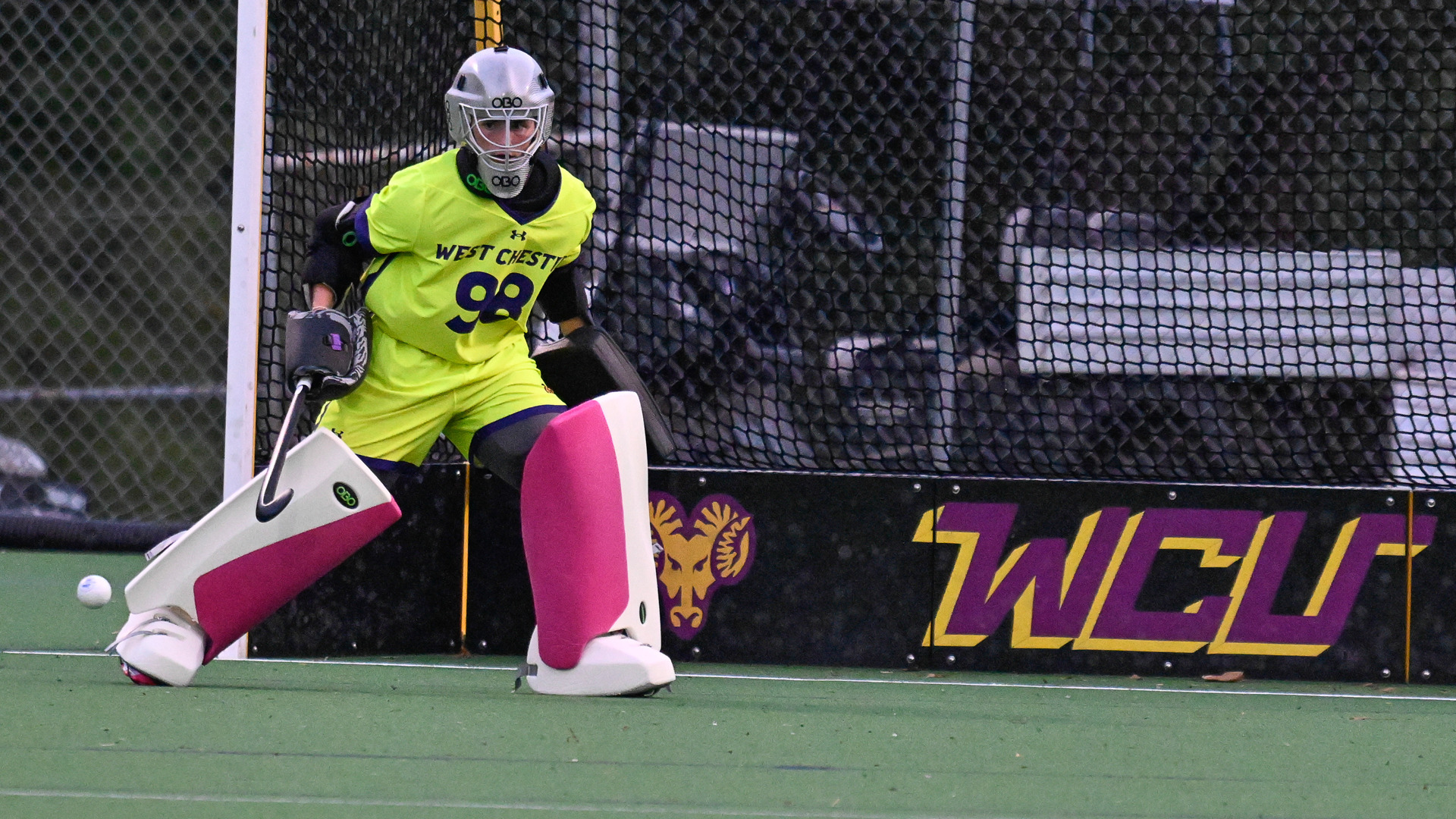 Erin O'Brien tracks the ball across the front of the goal against Assumption in her yellow highlight uniform with white leg pads and pink design