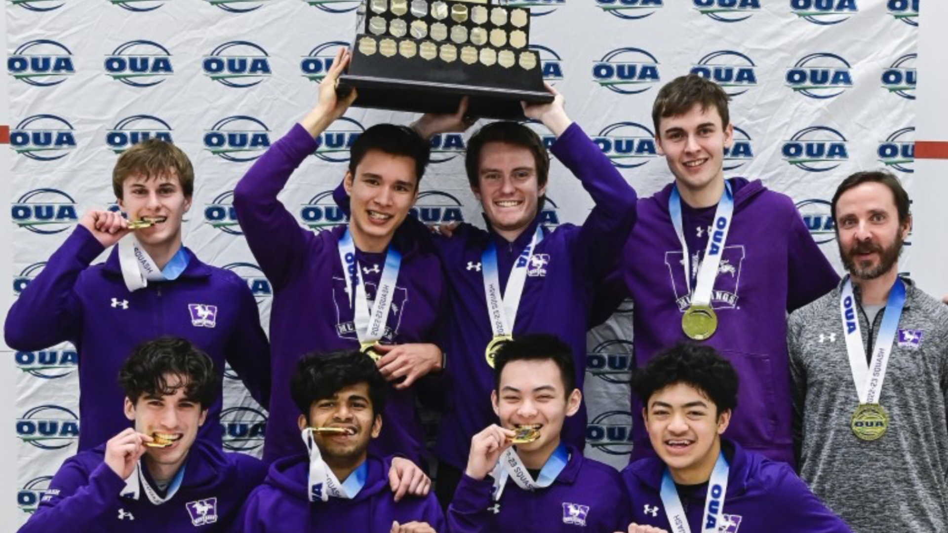 mens squash team hoists trophy