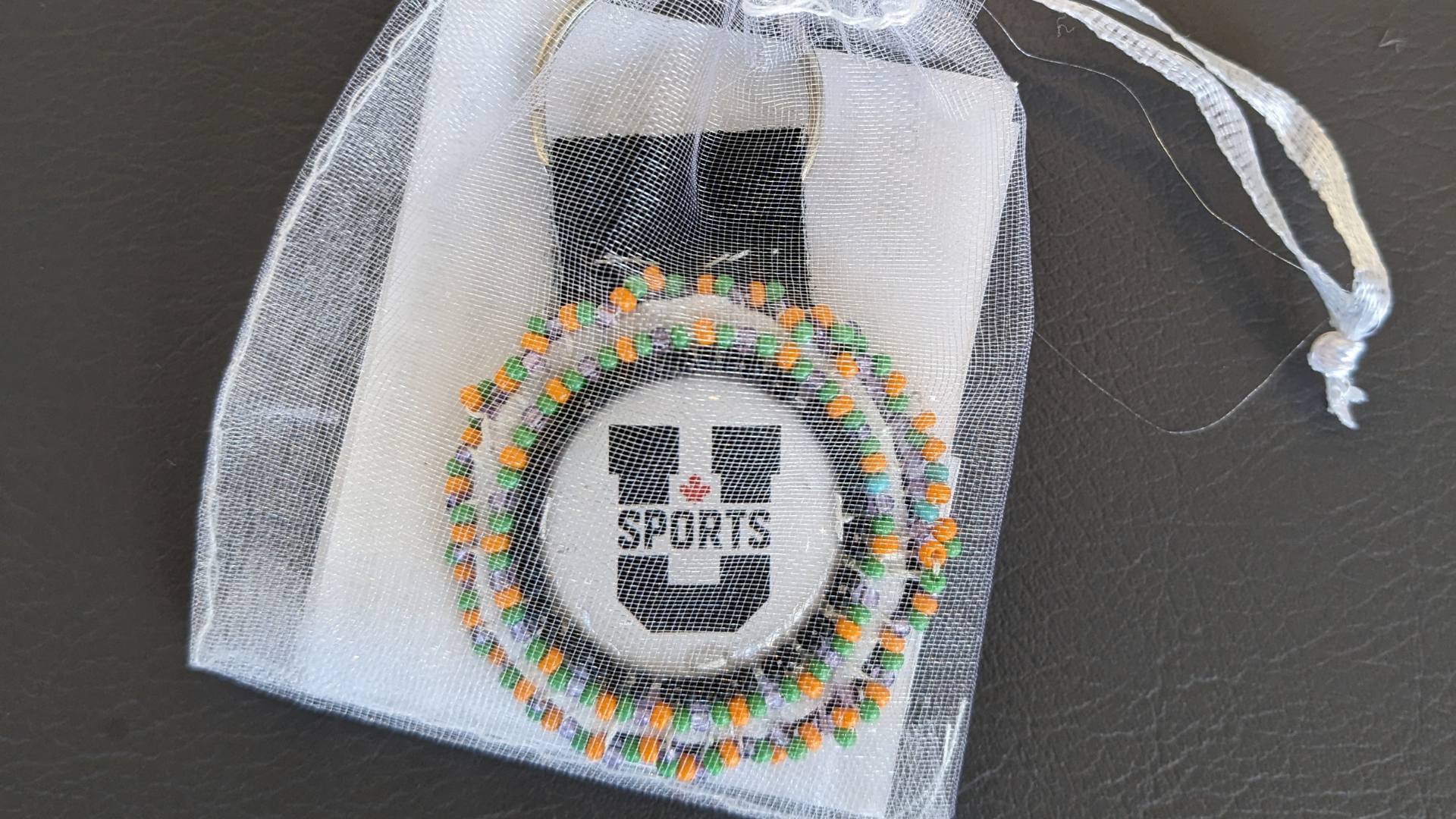 Indigenous Beadwork Key Chain for U SPORTS CC National Championship - inside a white see through pouch.