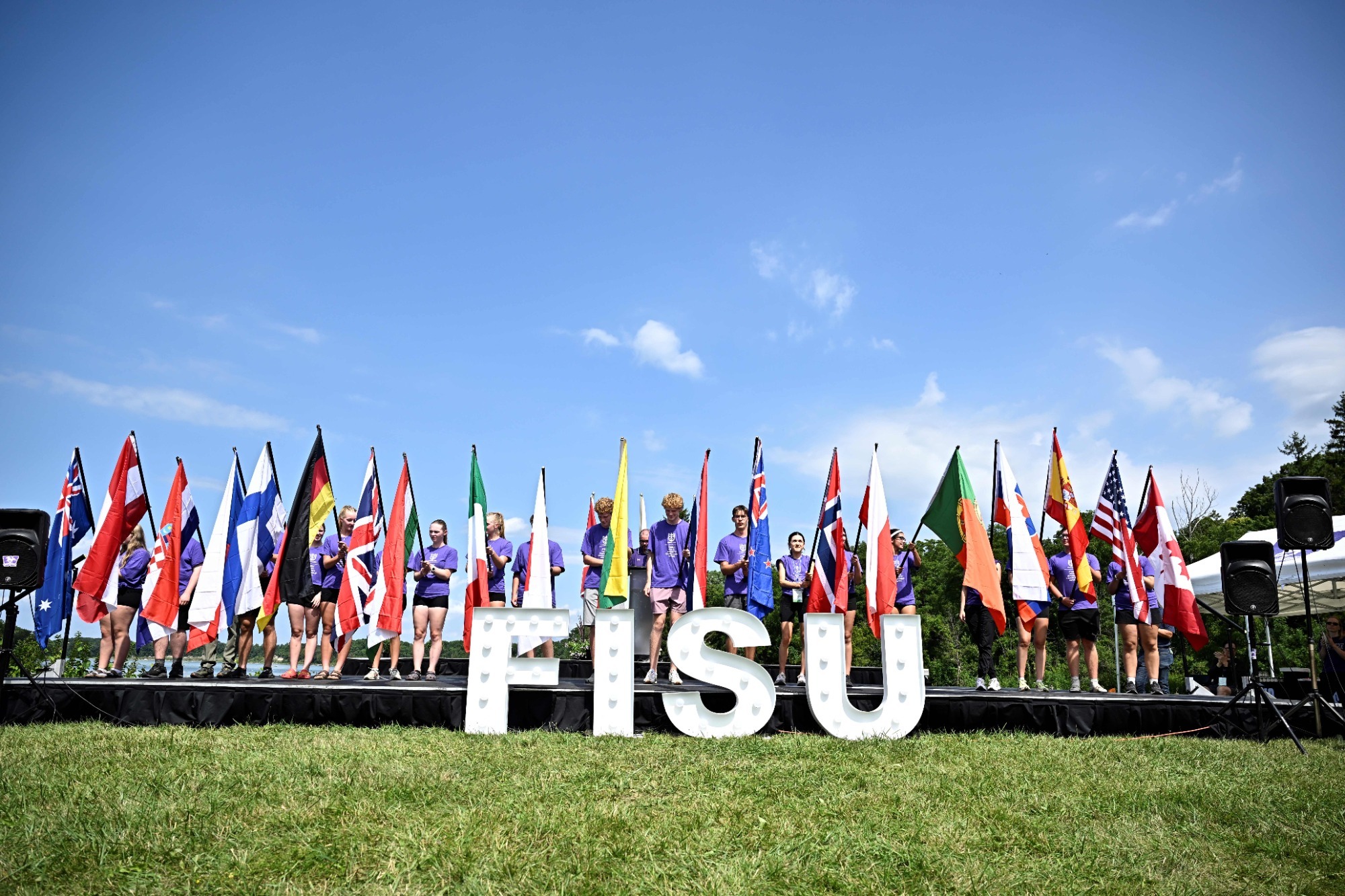 FISU Rowing 2026 image at the lake, blue sky, flags of competing nations, FISU letters
