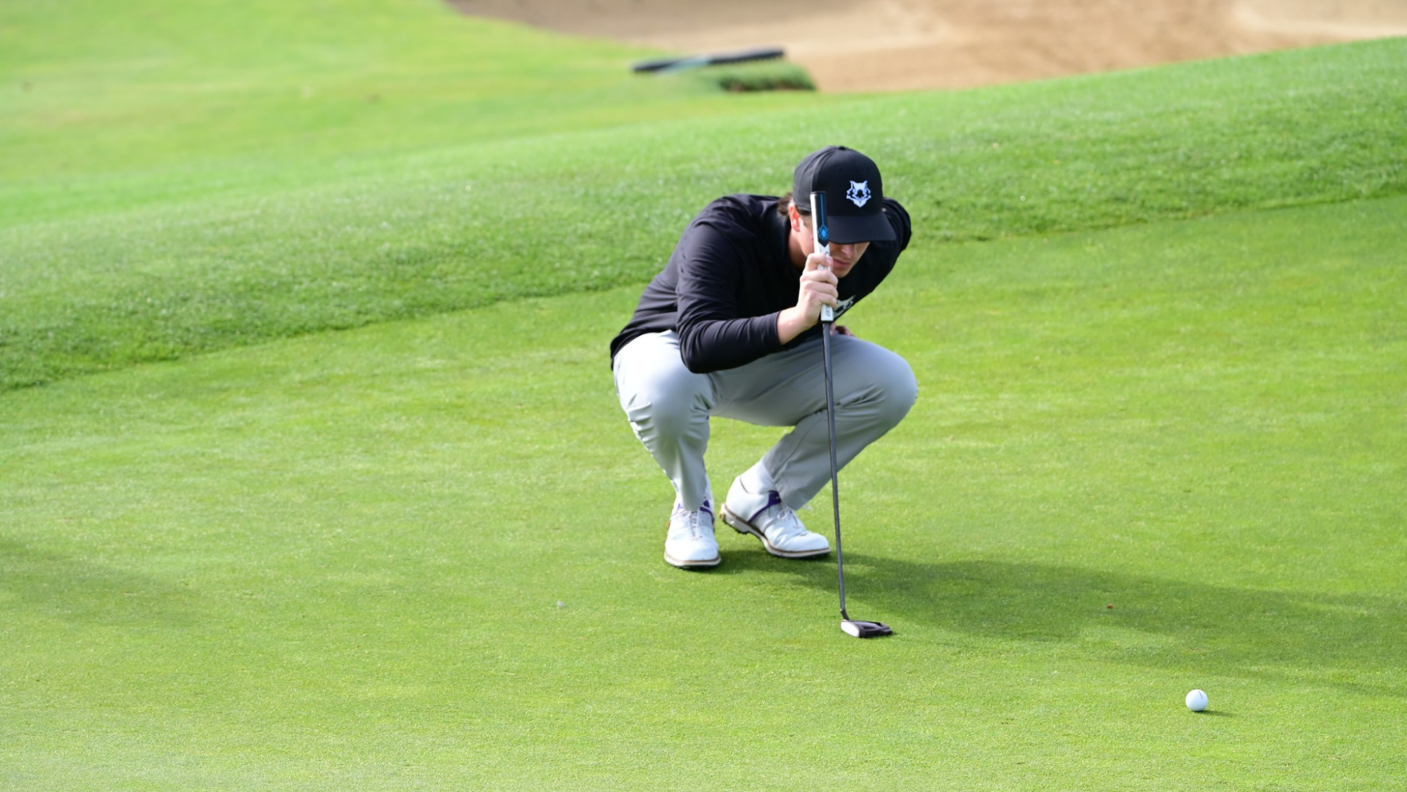 Mens golf lining up a putt