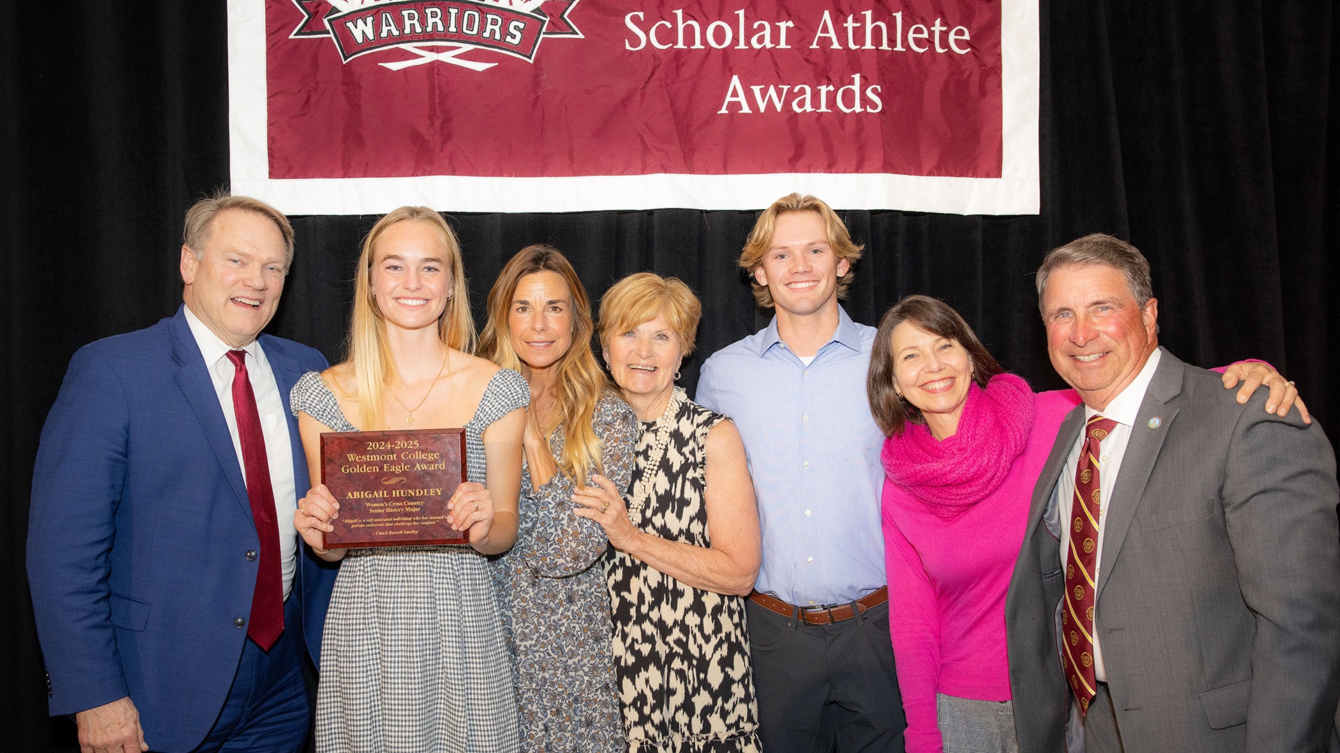 Abigail Hundley (second from left) and family. Left: Westmont President Gailey Beebe. Right: Westmont Head Coach Russ Smelley (Photo by Brad Elliott)