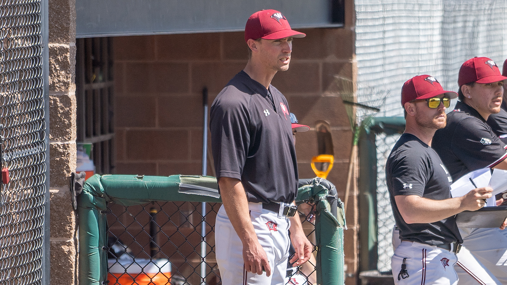 Head coach CJ Perry coaches from the dugout in the opener vs. Whitman