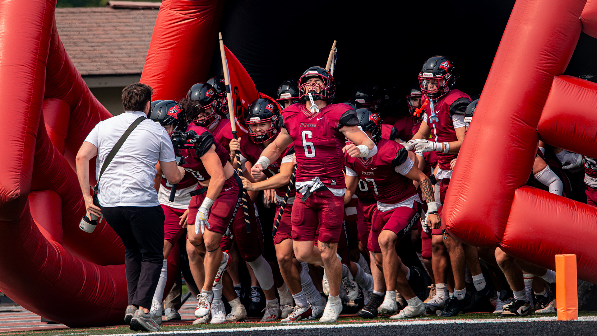 The Pirates emerge from the helmet prior to Saturday's kickoff vs. Gustavus Adolphus