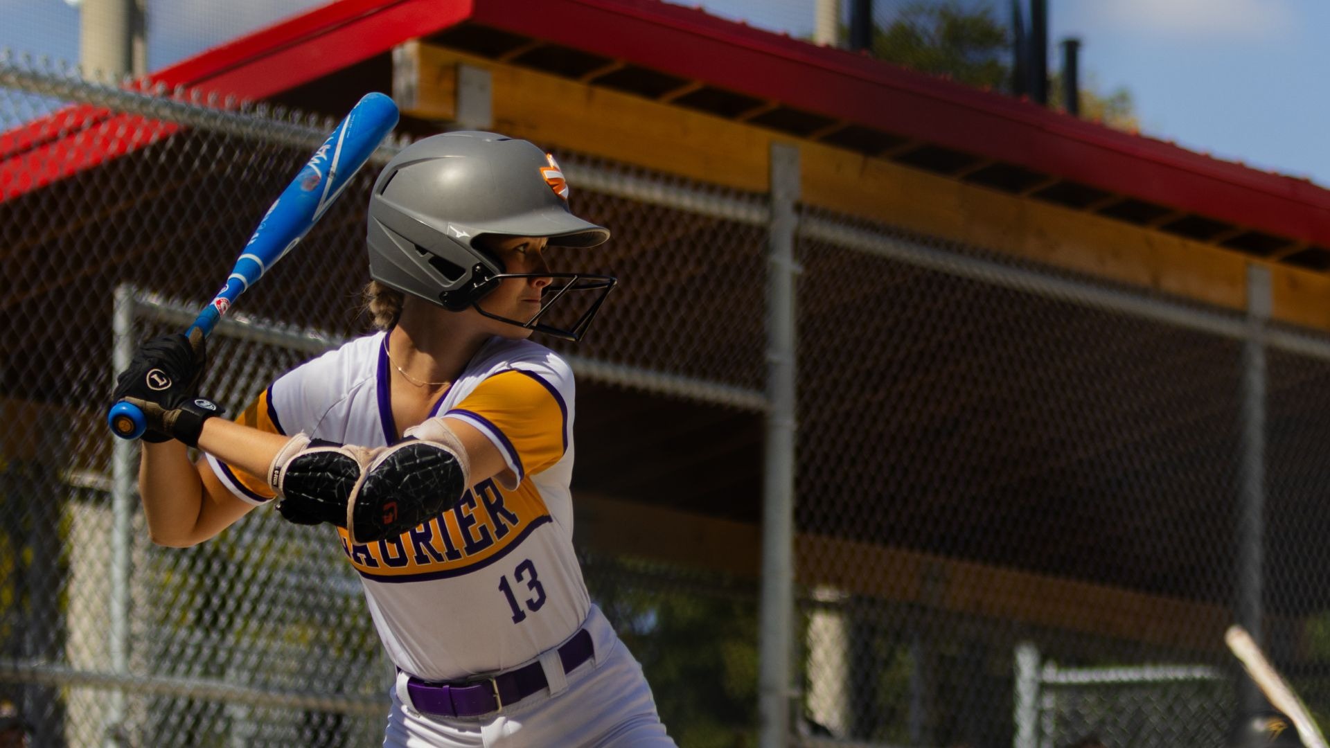 A Laurier women's softball player winds up to bat