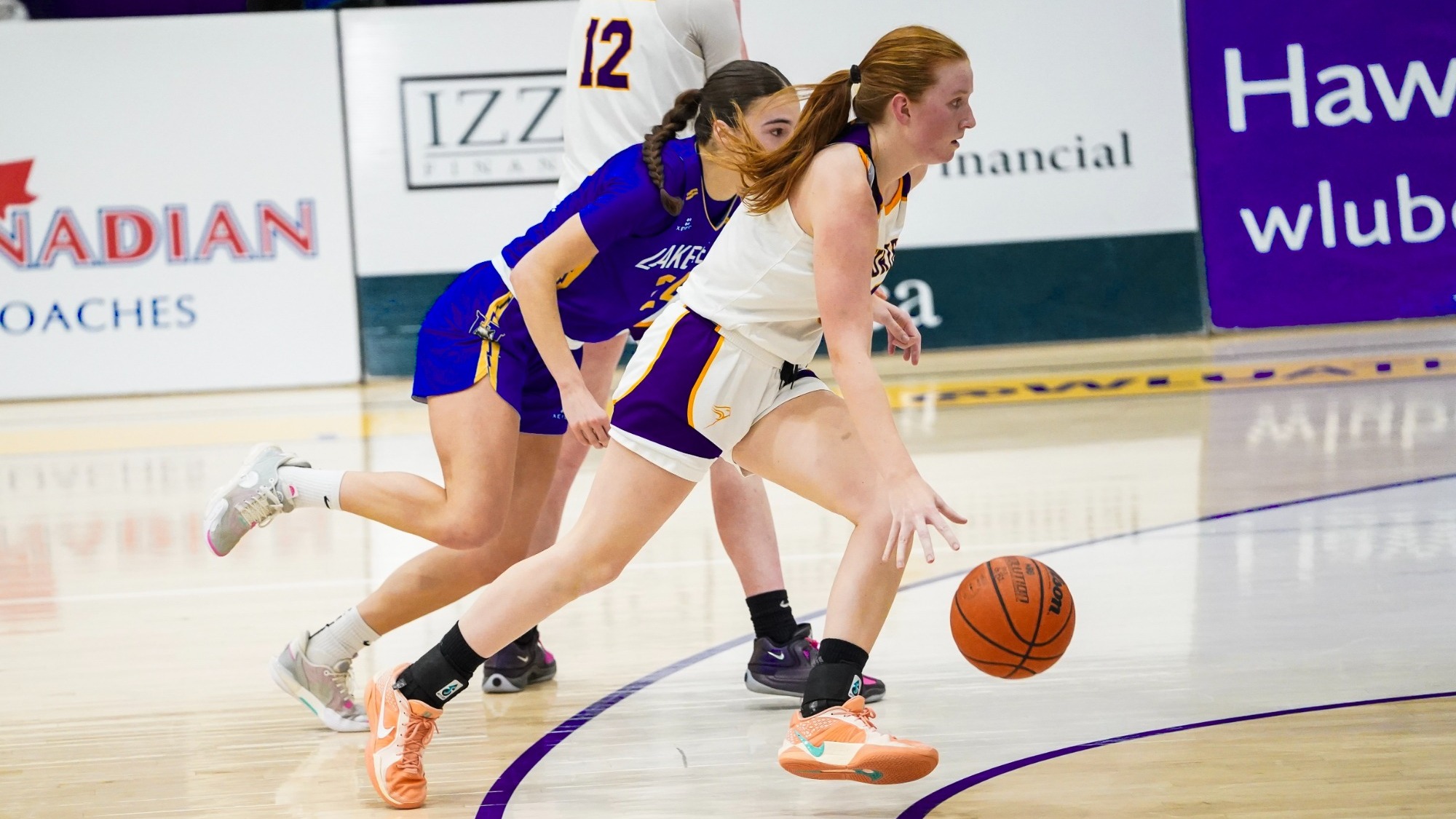 Kate White dribbles past a Lakehead player