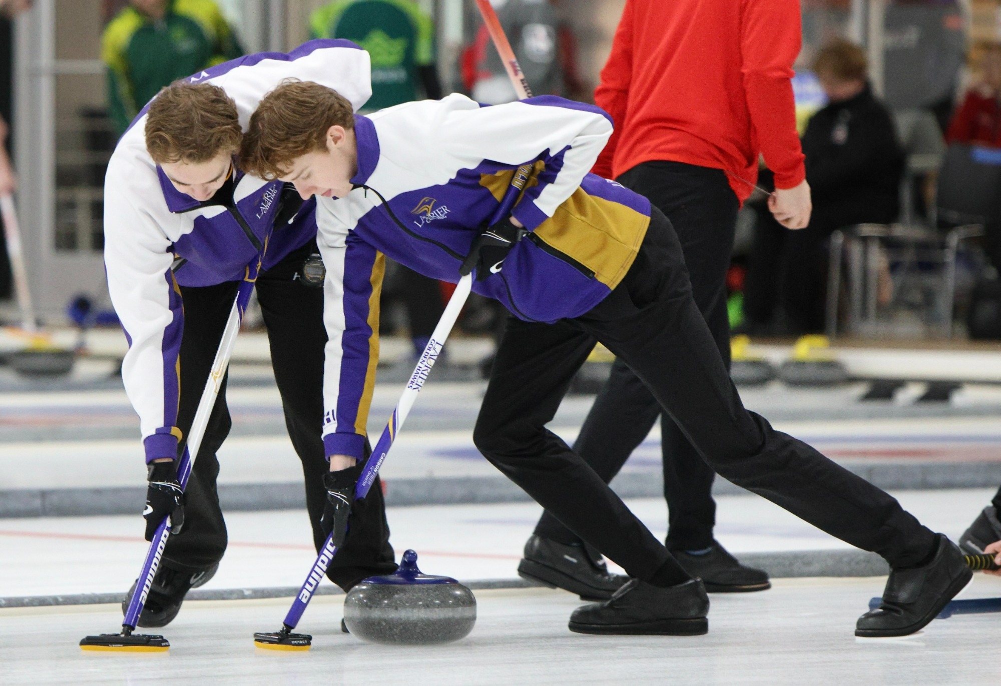 Wyatt Wright and Wyatt Small sweep a Laurier rock.