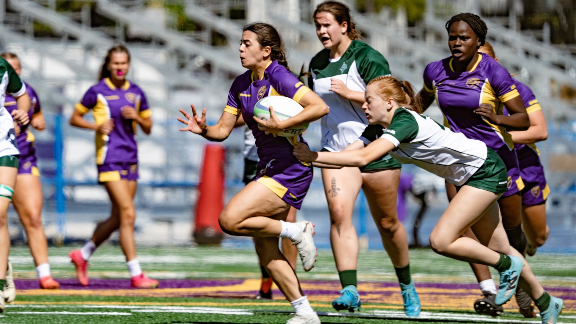 Laurier women's rugby runs away from a Trent defender.