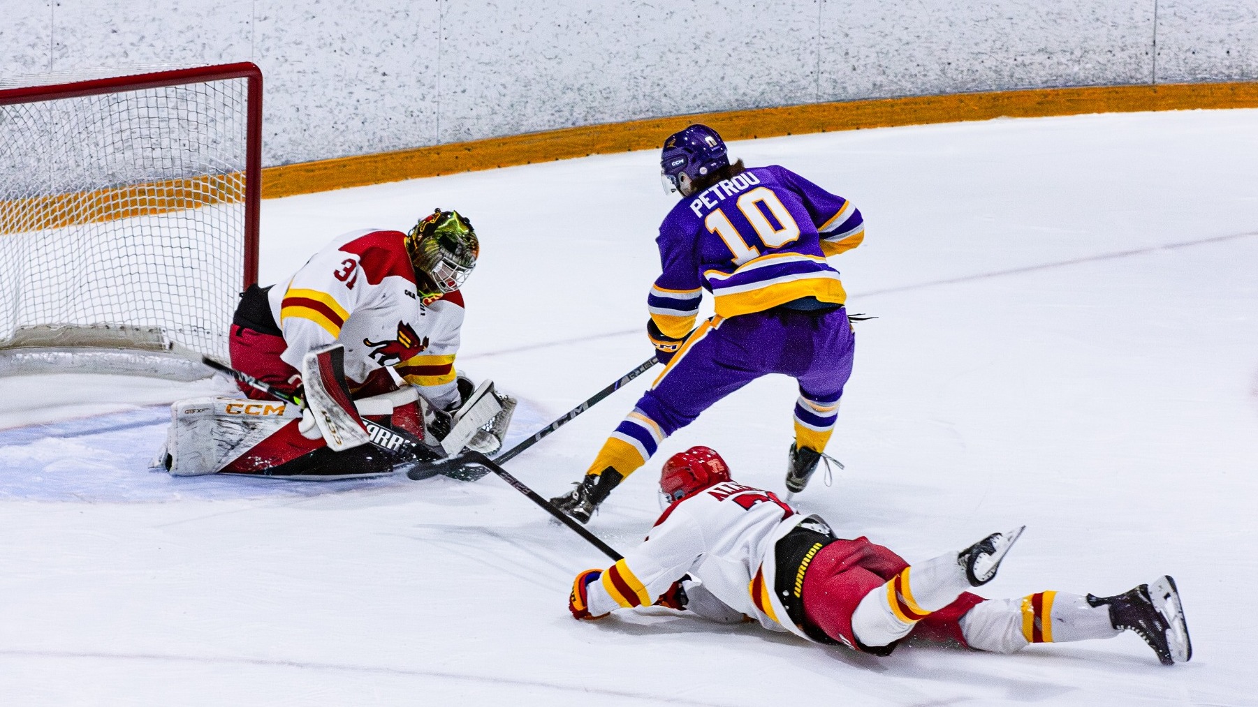 Ty Petrou makes a move on the Guelph goaltender with a diving defender behind.