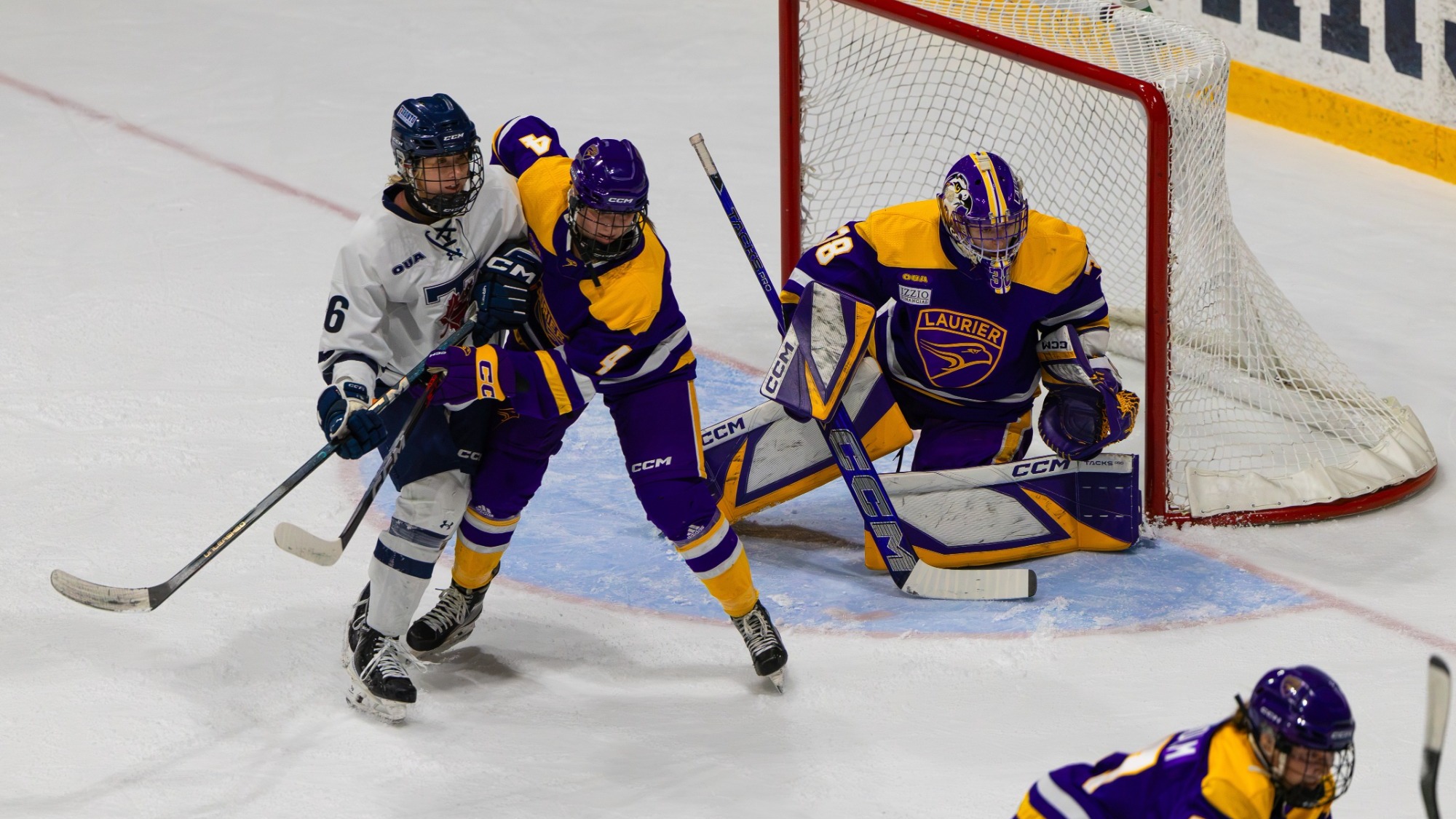 Laurier and Toronto jostle for positioning in front of the net.