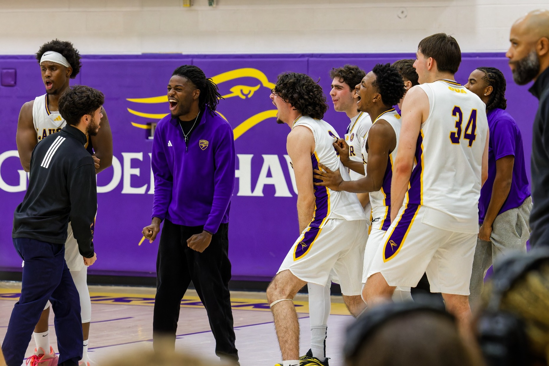 Laurier men's basketball celebrate a win over TMU