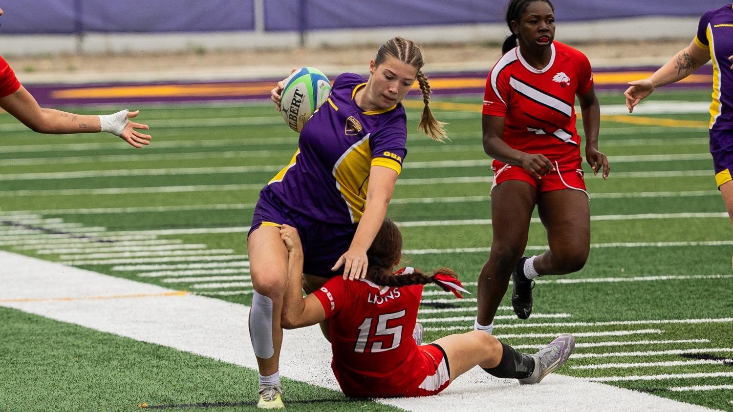 Laurier women's rugby push down a York defender.