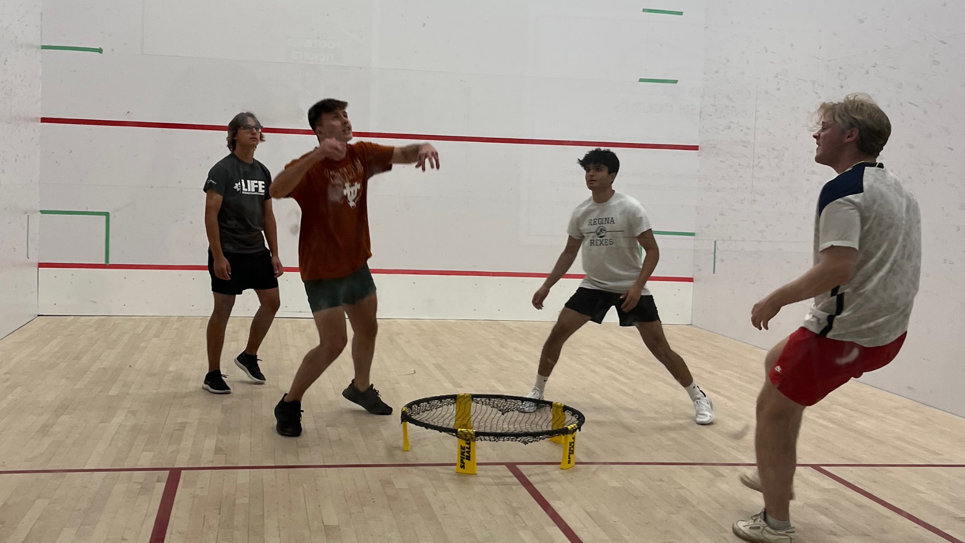 Four males playing spikeball