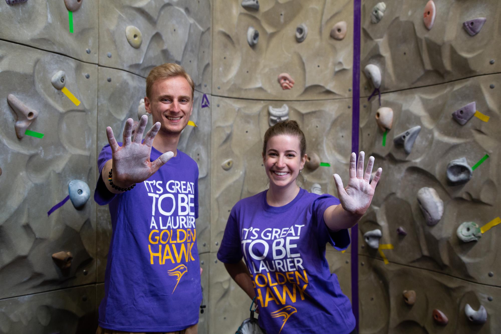 Climbing wall staff with hands covered in chalk