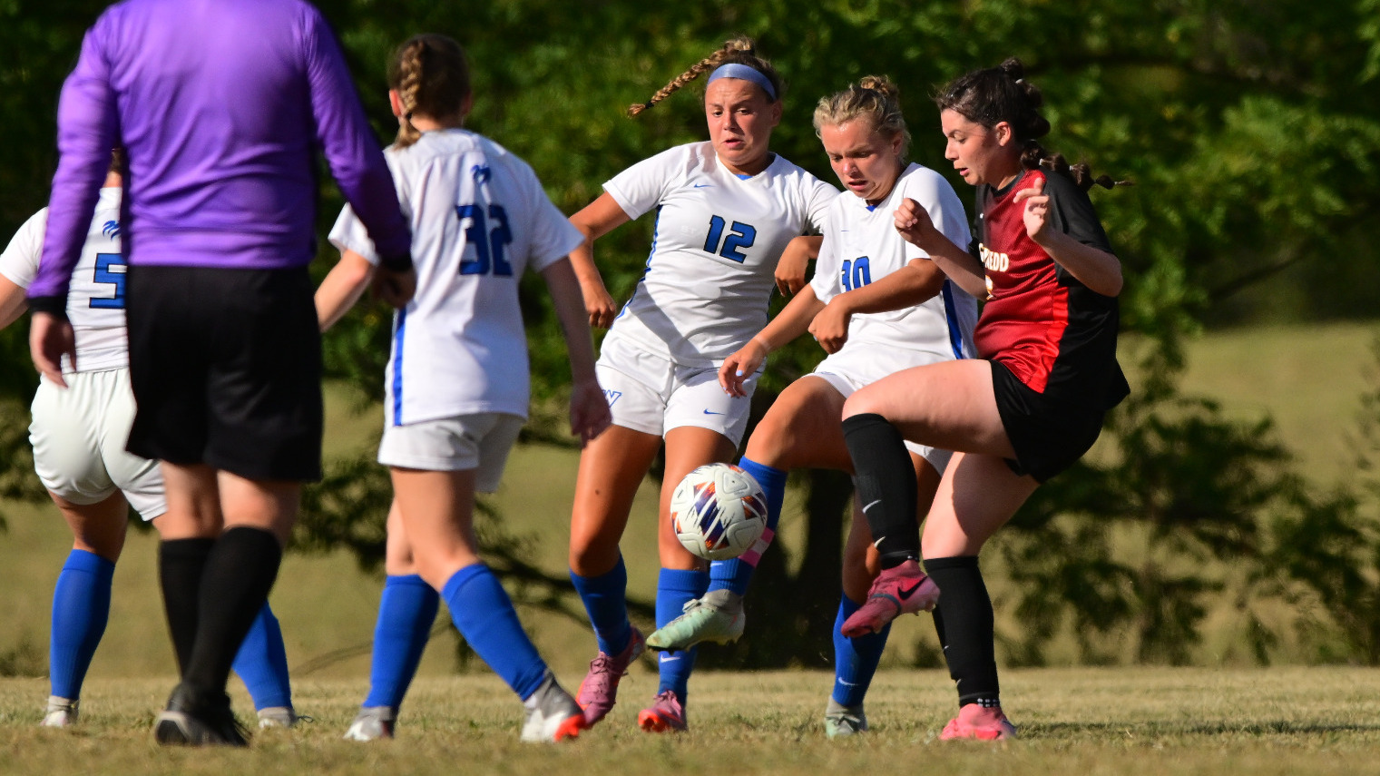 Ella Schmoyer and Reilly Ryan battle for the ball against an opposing player