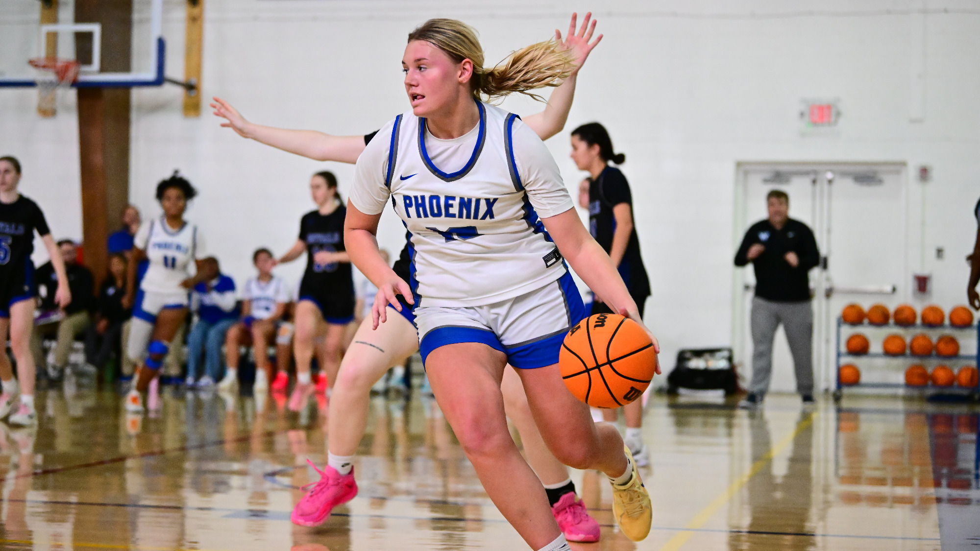 Chelcie Forrester dribbles to ball out along the baseline while being defended from behind.
