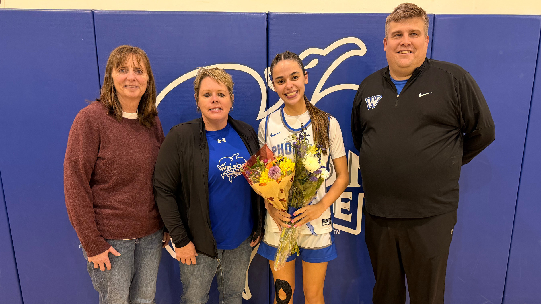 Former head coach Allison Steiger, Theresa Phelps Denhoff '01, Jewels Torres, and current head coach Dylan Ward pose for a picture
