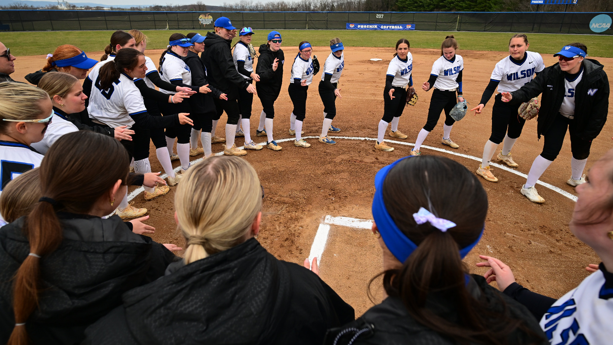 Team does a pregrame ritual at the pitcher's circle